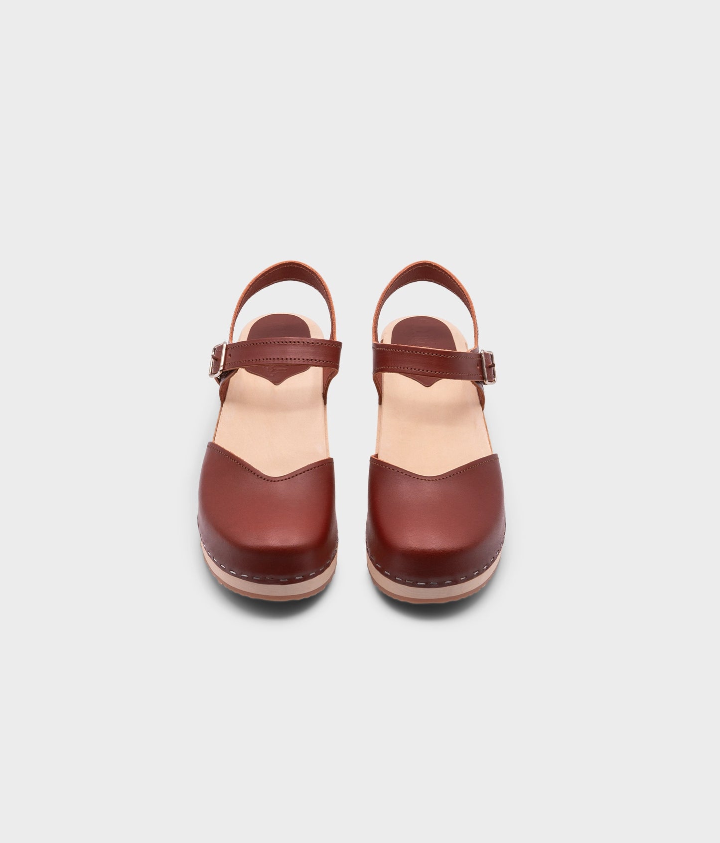 classic low heeled closed-toe sandal in cognac red vegetable tanned leather stapled on a light wooden base