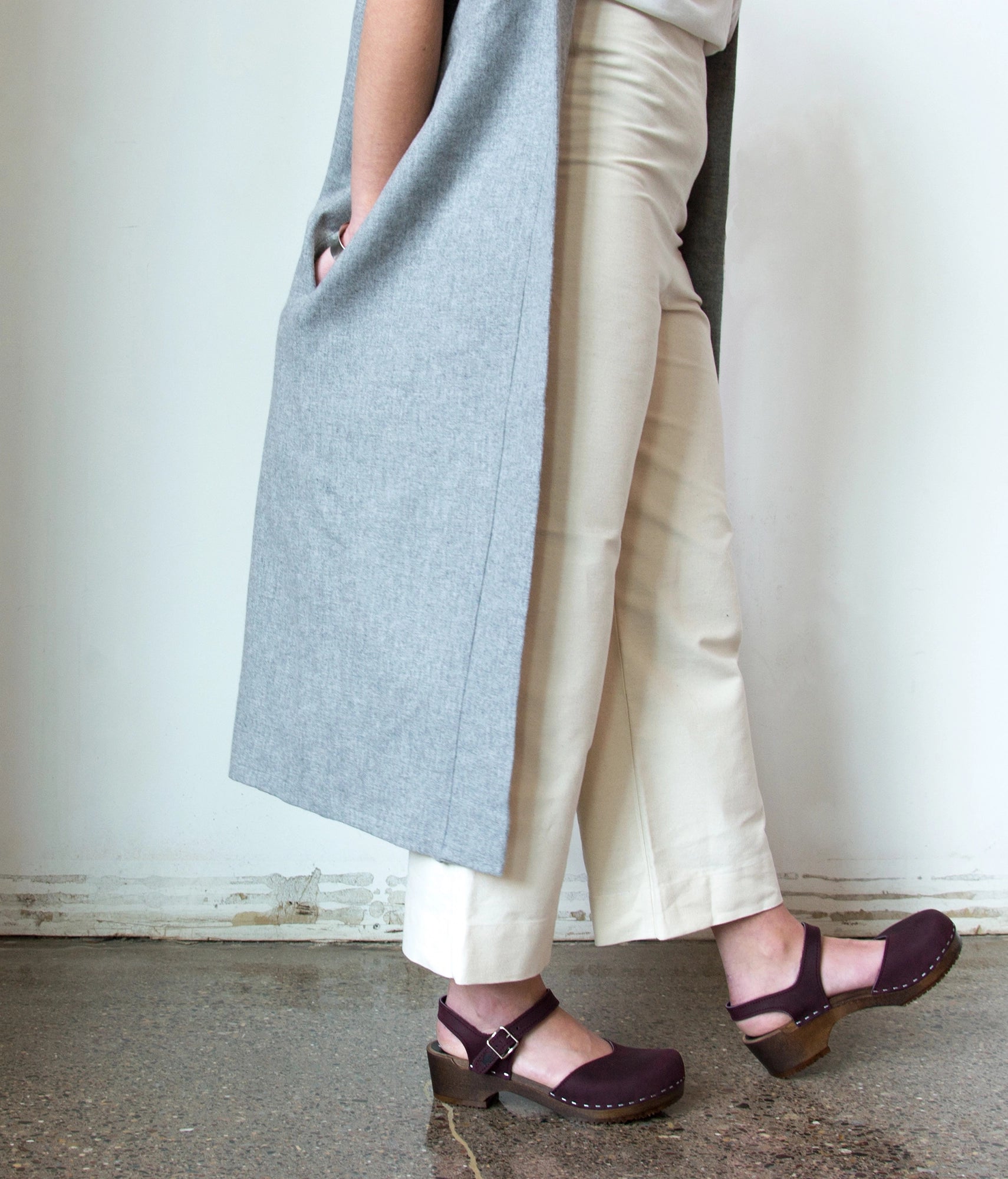 classic low heeled closed-toe sandal in purple plum nubuck leather stapled on a dark wooden base
