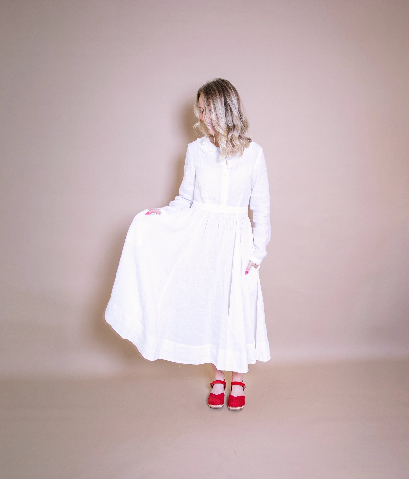 classic low heeled closed-toe sandal in red nubuck leather stapled on a light wooden base