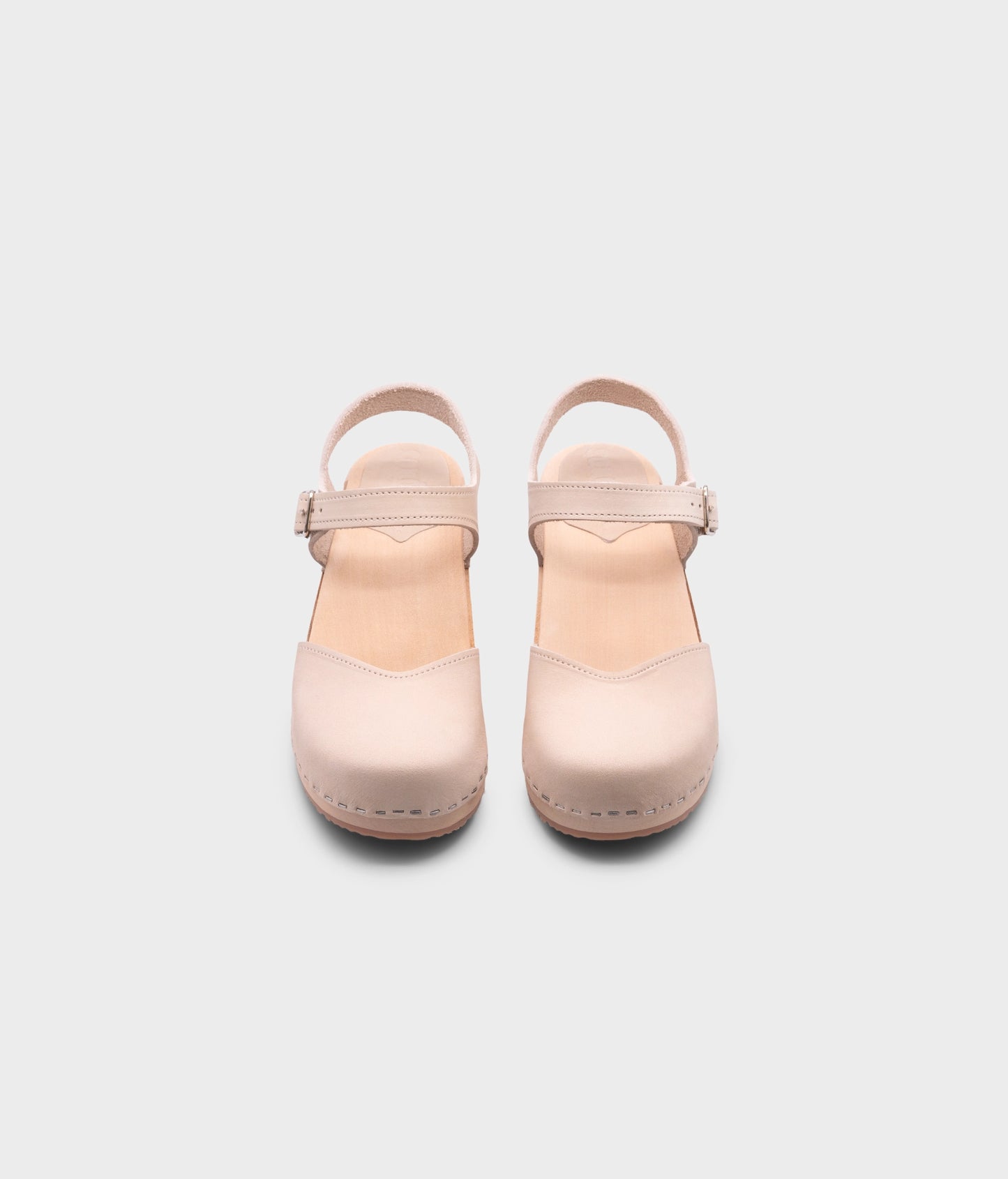 classic low heeled closed-toe sandal in sand white nubuck leather stapled on a light wooden base