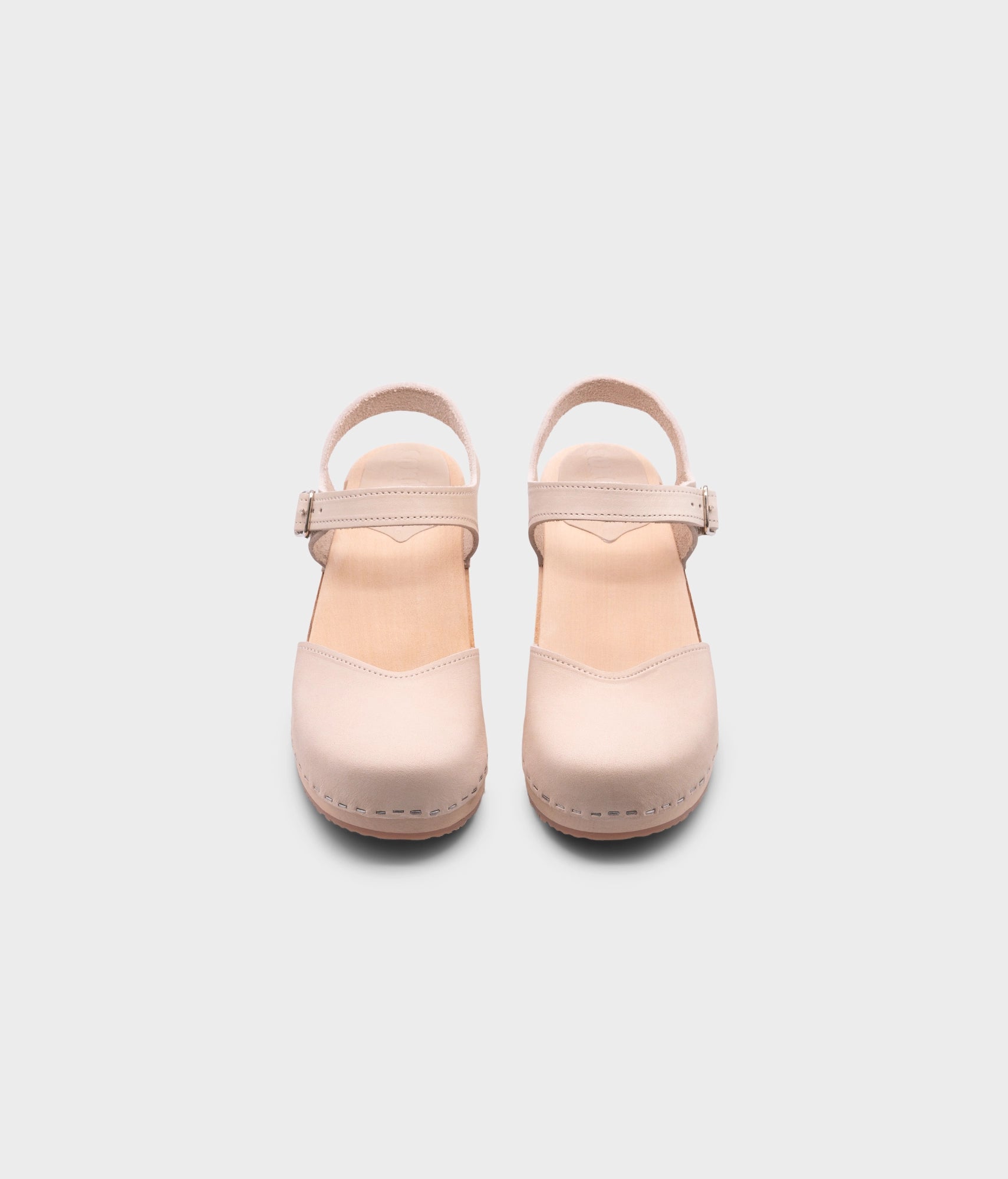 classic low heeled closed-toe sandal in sand white nubuck leather stapled on a light wooden base