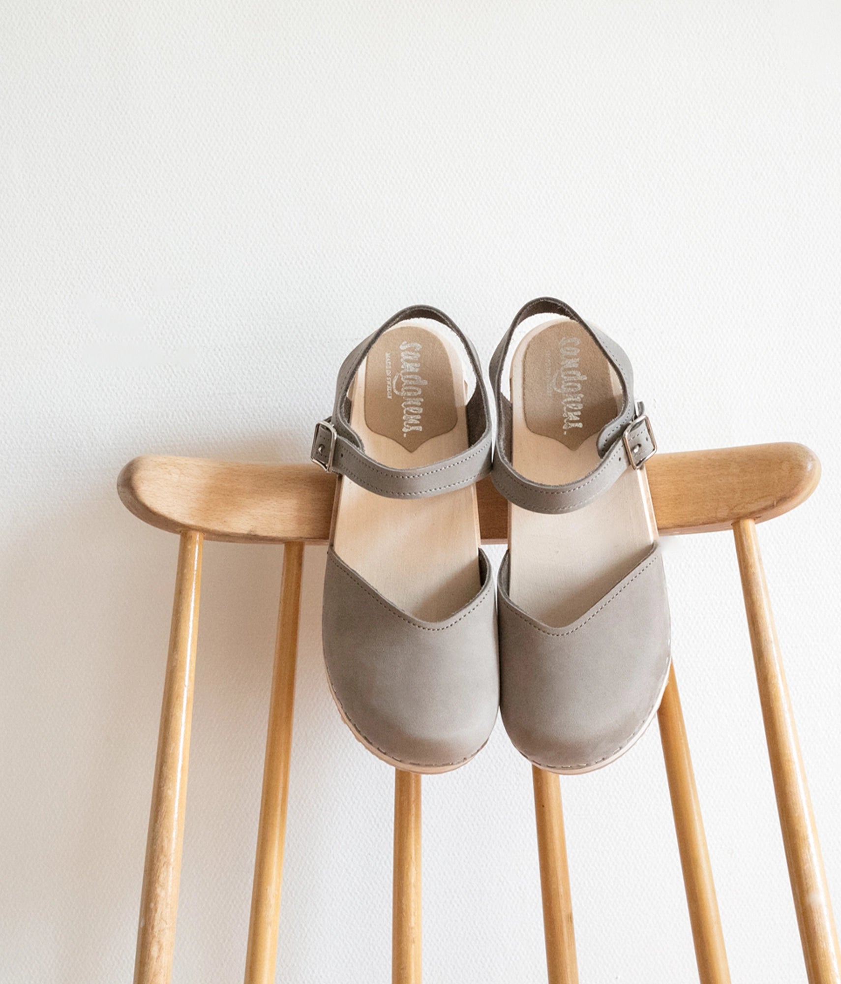 classic low heeled closed-toe sandal in stone grey nubuck leather stapled on a light wooden base
