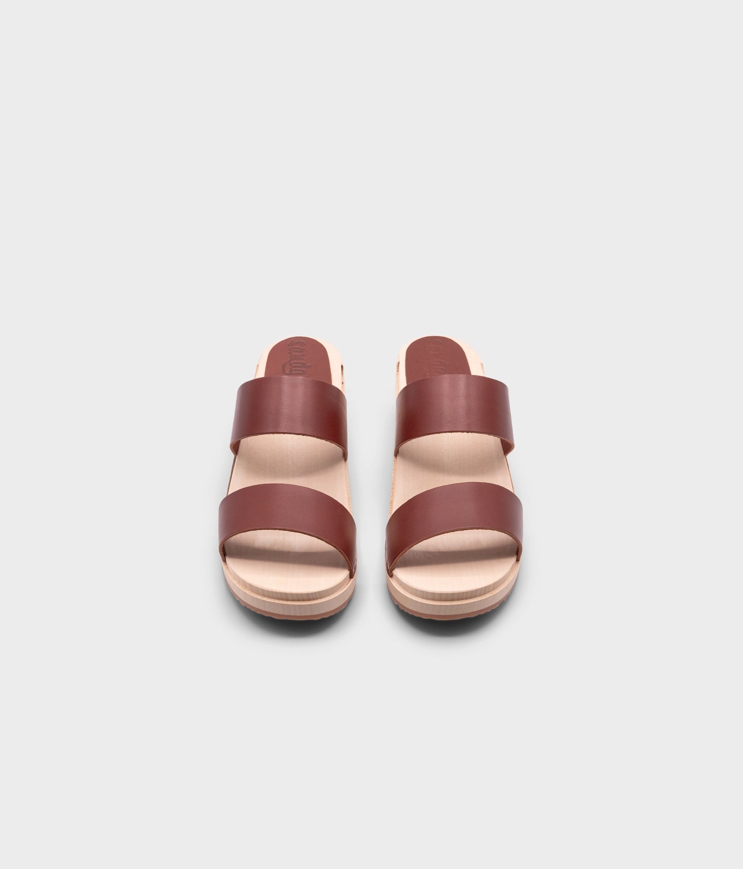 low heeled slip-in clog sandal with open toe in cognac red vegetable tanned leather stapled on a light wooden base