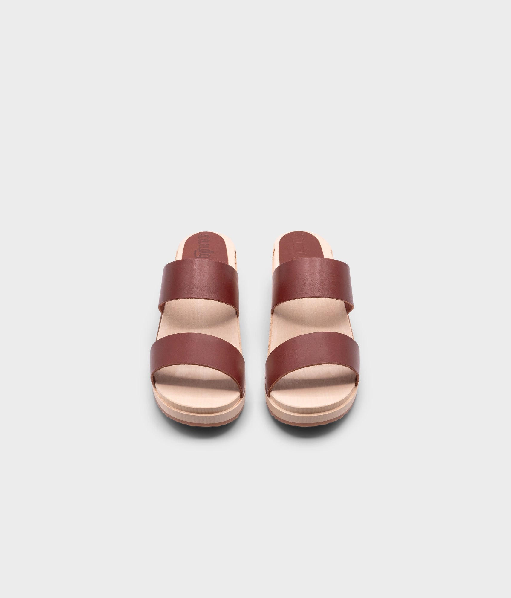 low heeled slip-in clog sandal with open toe in cognac red vegetable tanned leather stapled on a light wooden base