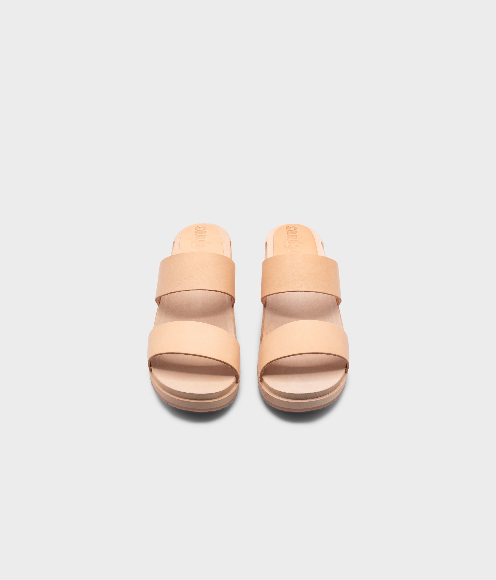 low heeled slip-in clog sandal with open toe in beige ecru vegetable tanned leather stapled on a light wooden base