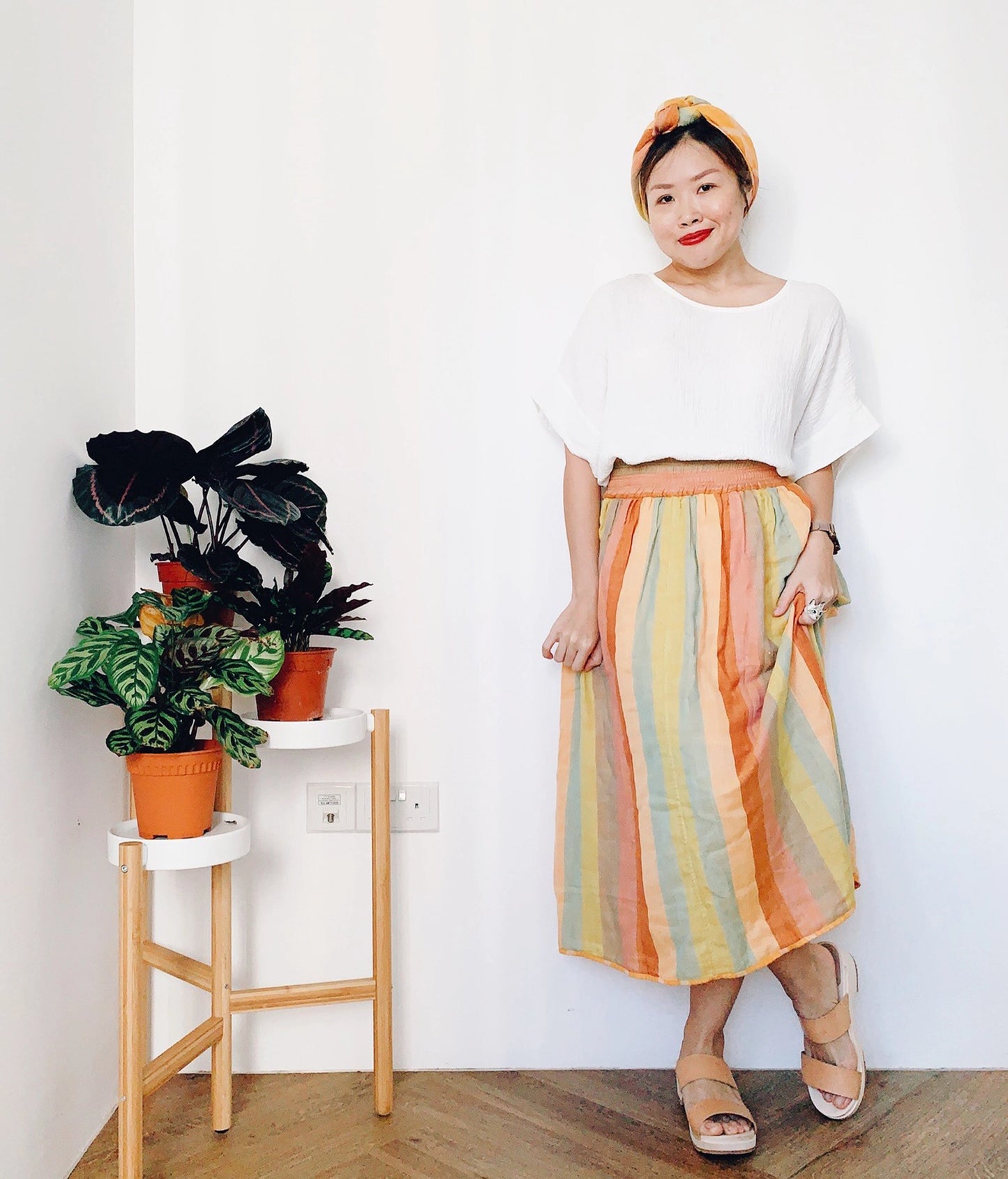 woman wearing low heeled slip-in clog sandal with open toe in beige ecru vegetable tanned leather stapled on a light wooden base