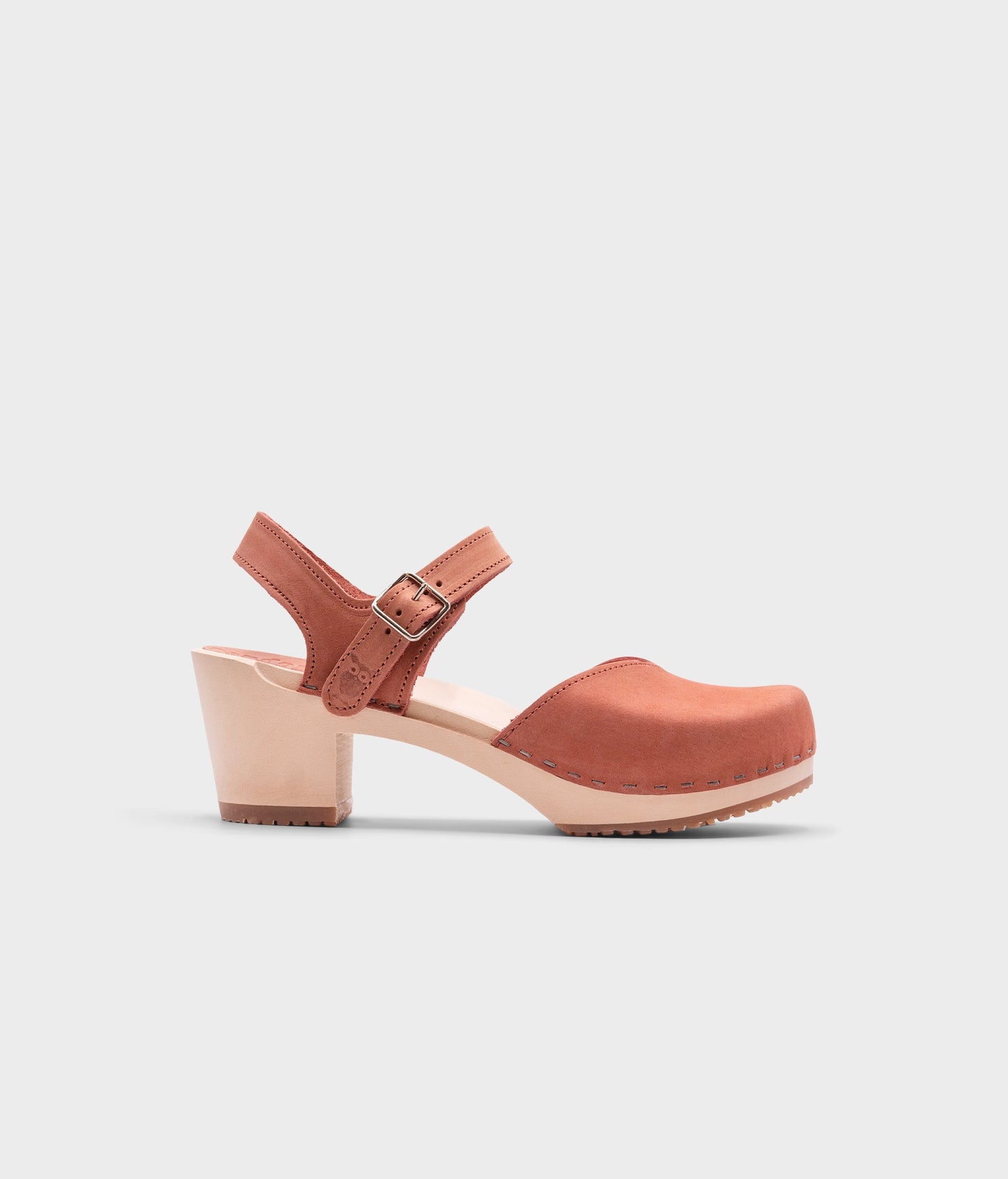 high heeled closed-toe clog sandal in blush pink nubuck leather stapled on a light wooden base