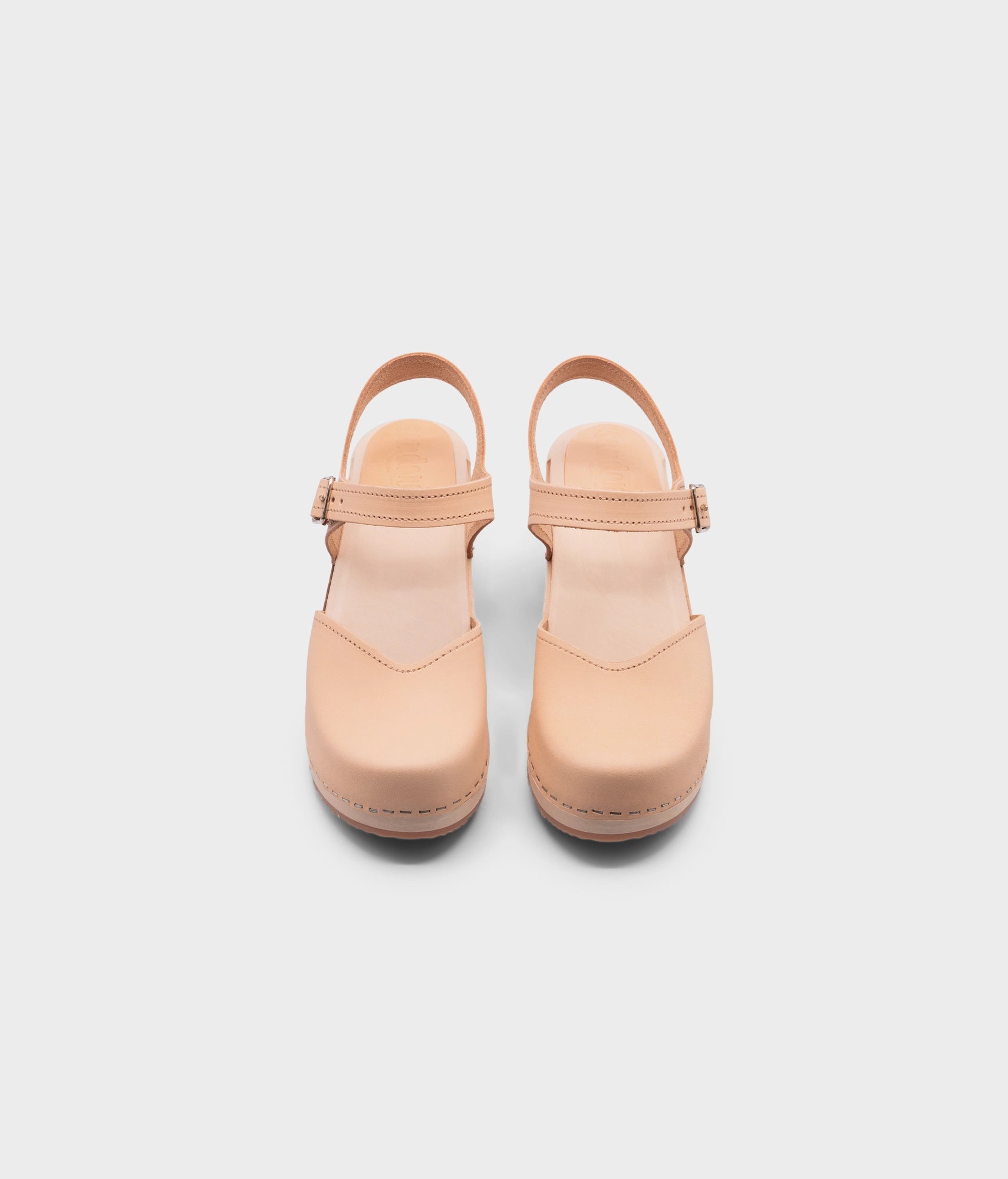high heeled closed-toe clog sandal in ecru beige vegetable tanned leather stapled on a light wooden base