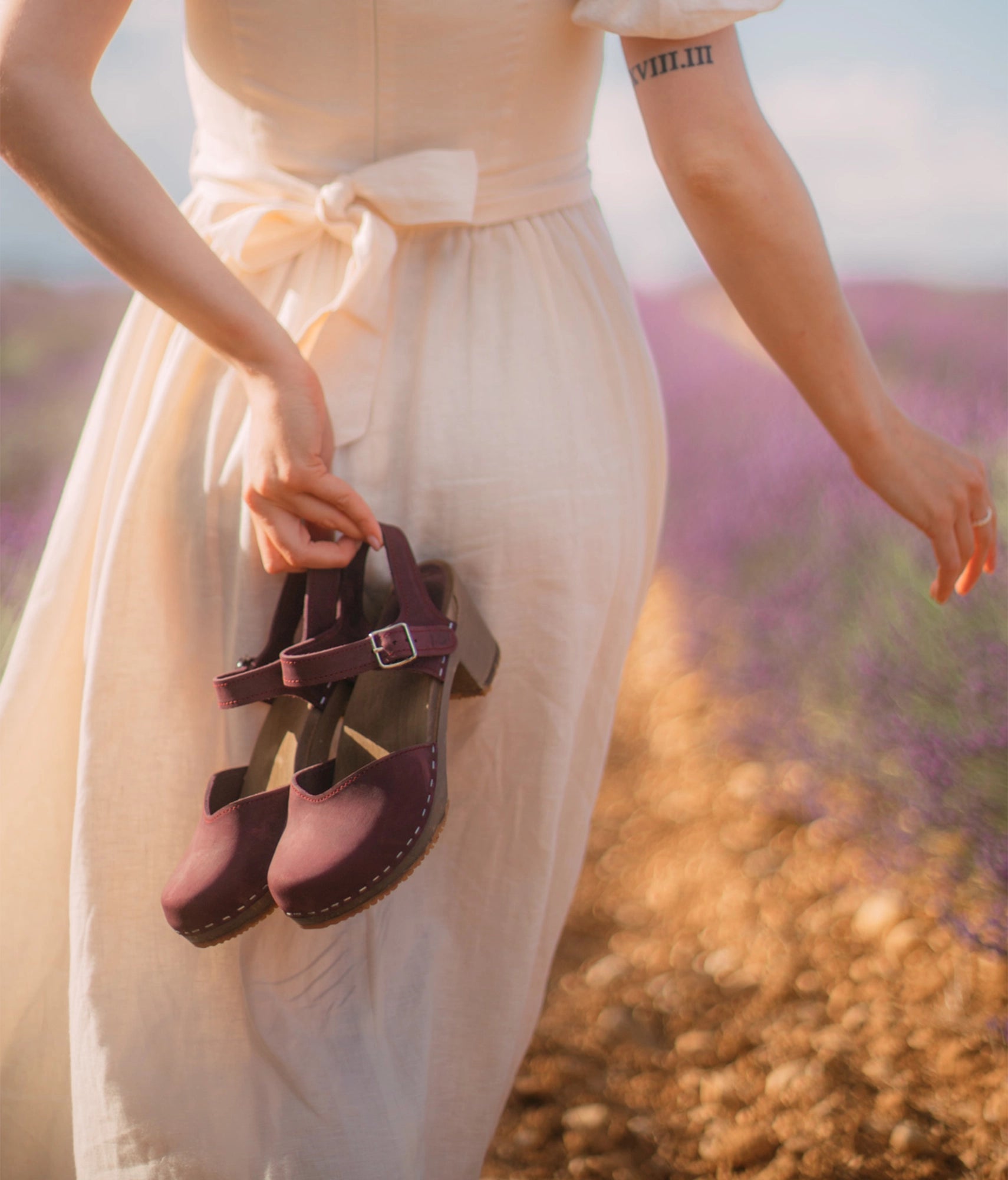high heeled closed-toe clog sandal in purple plum nubuck leather stapled on a dark wooden base