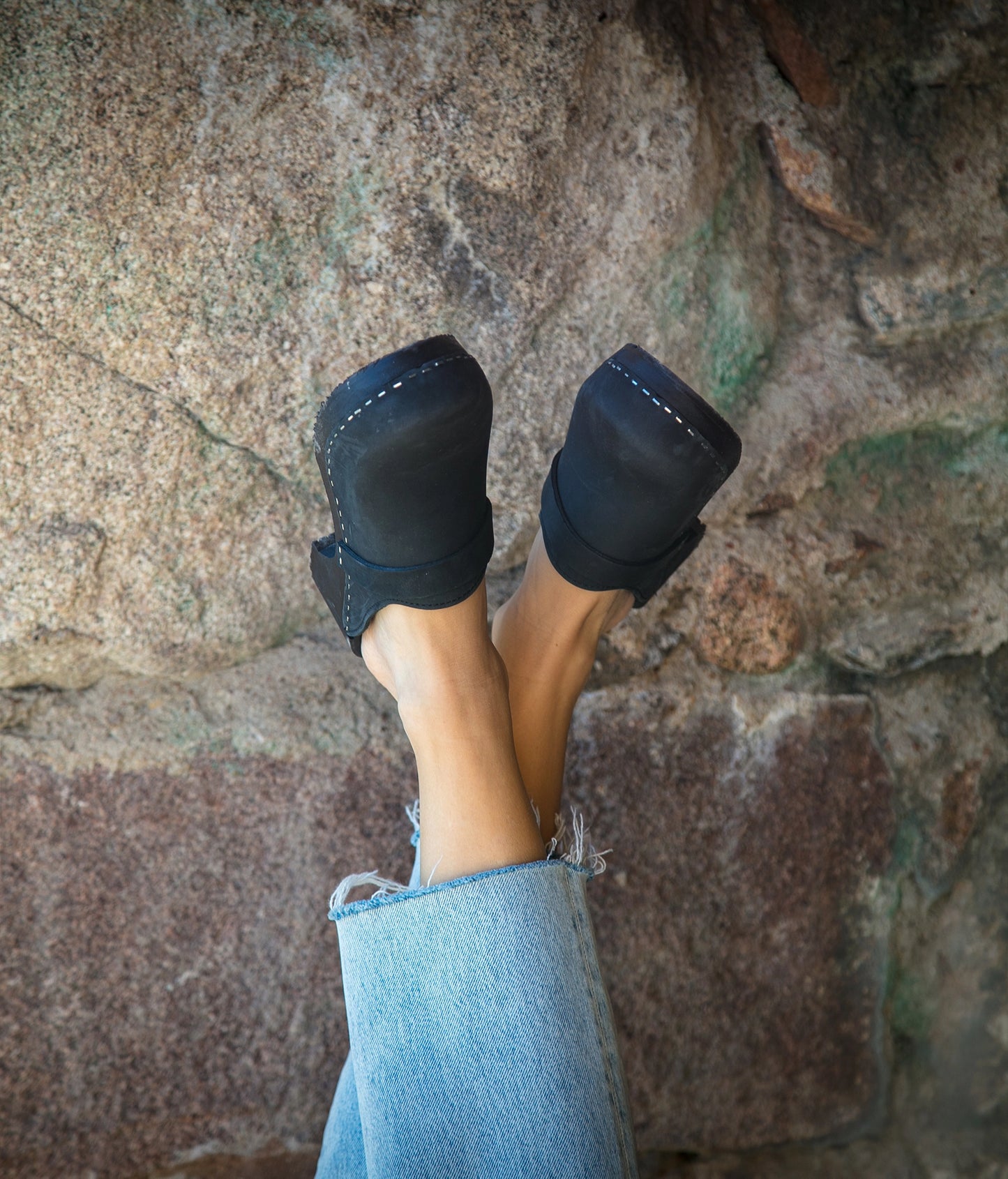 classic low heeled clog mule in black nubuck leather stapled on a black wooden base with a leather strap