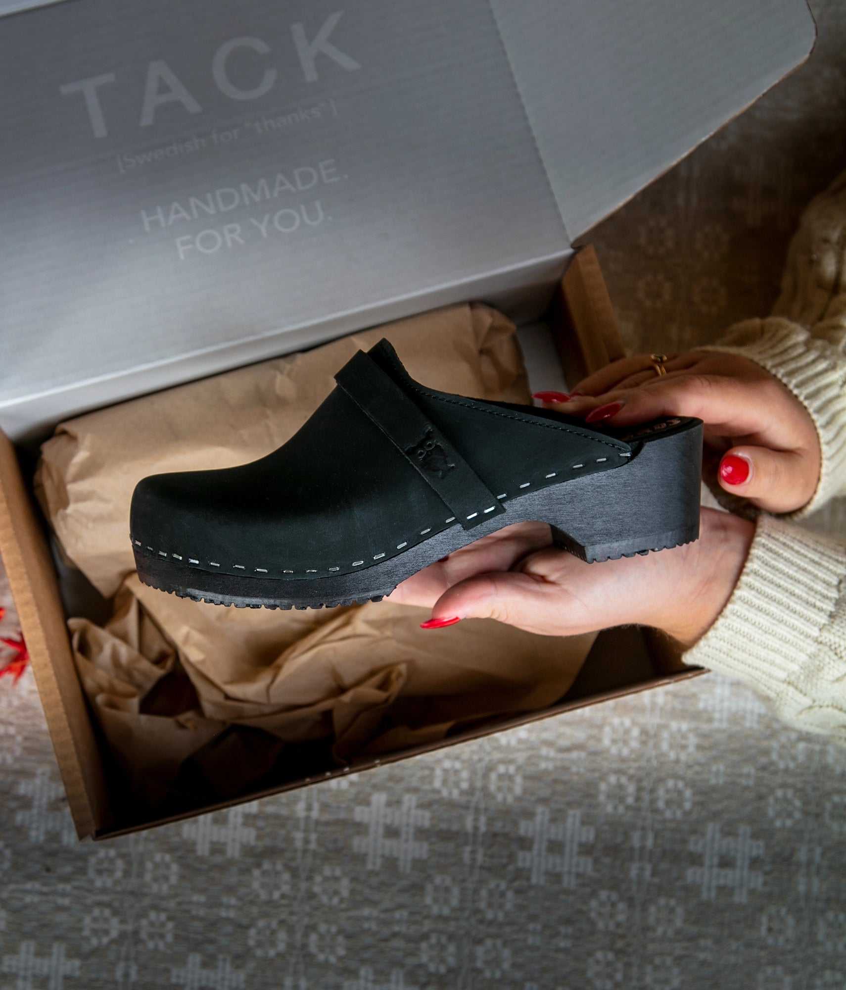classic low heeled clog mule in black nubuck leather stapled on a black wooden base with a leather strap