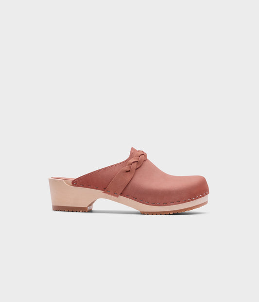 low heeled clog mules in blush pink nubuck leather with a braided strap stapled on a light wooden base