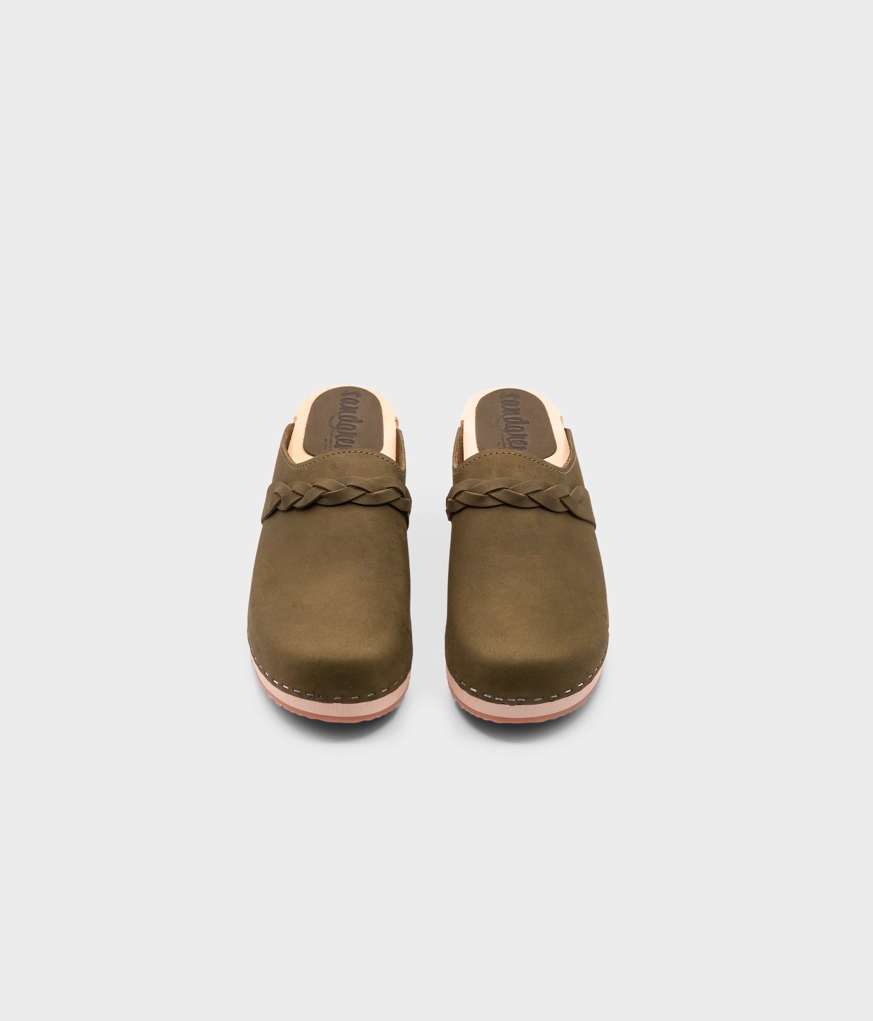low heeled clog mules in olive green nubuck leather with a braided strap stapled on a light wooden base