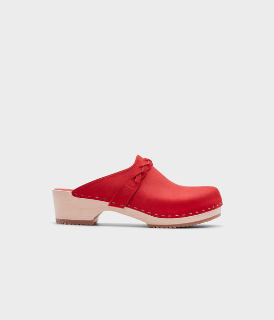 low heeled clog mules in red nubuck leather with a braided strap stapled on a light wooden base