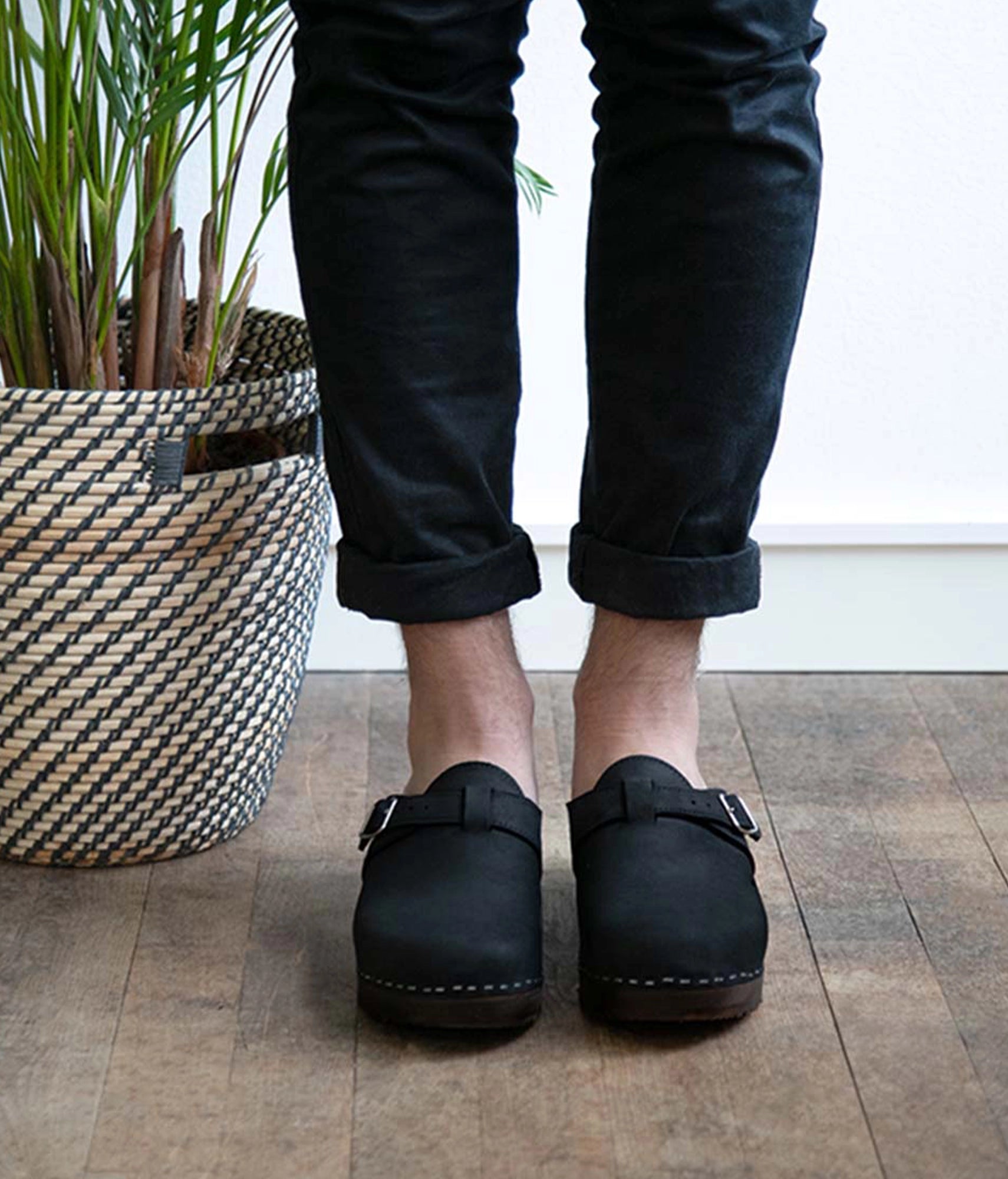 men's clog mule in black nubuck leather stapled on a dark wooden base with a silver buckle on top