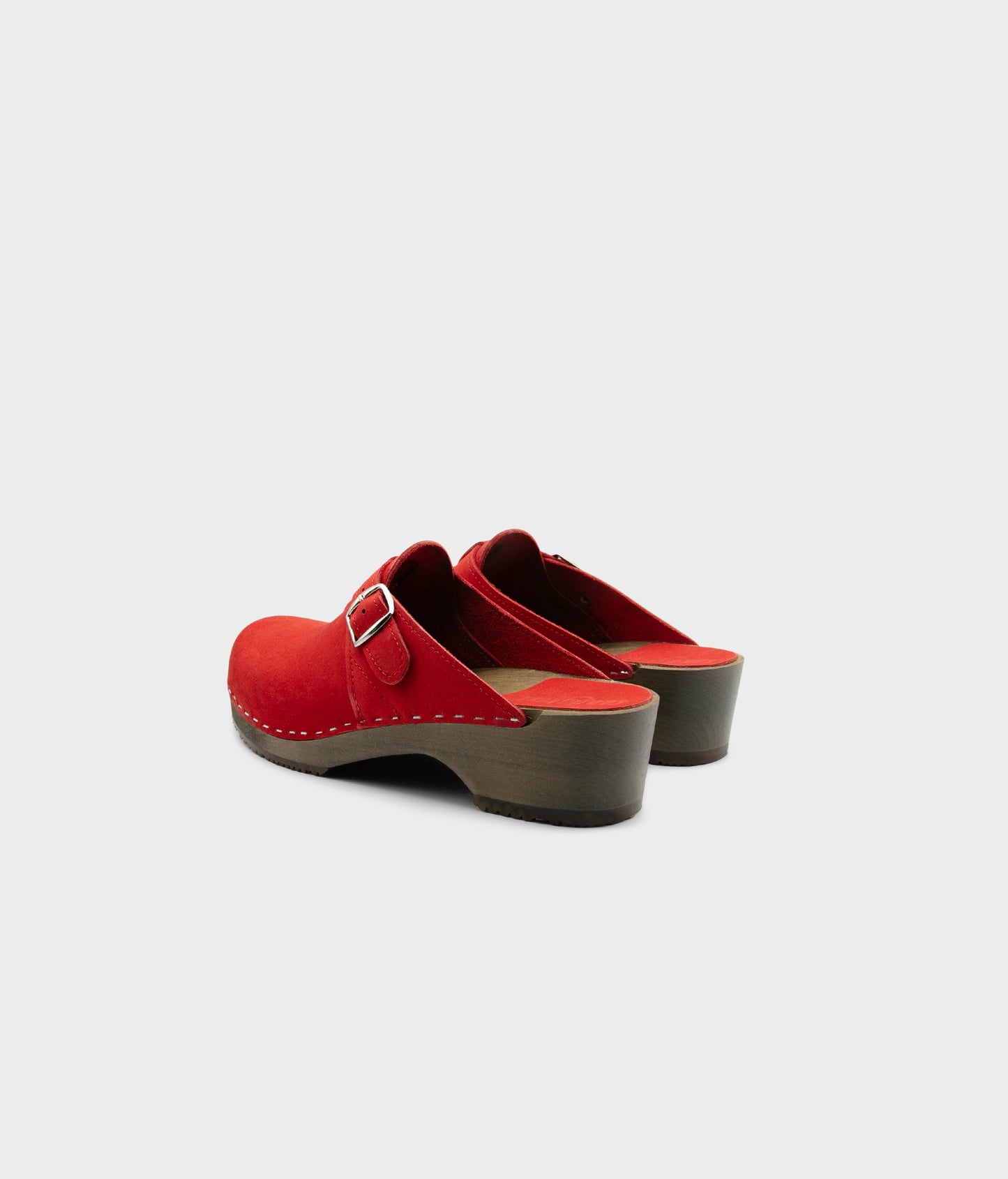 men's clog mule in black nubuck leather stapled on a dark wooden base with a silver buckle on top