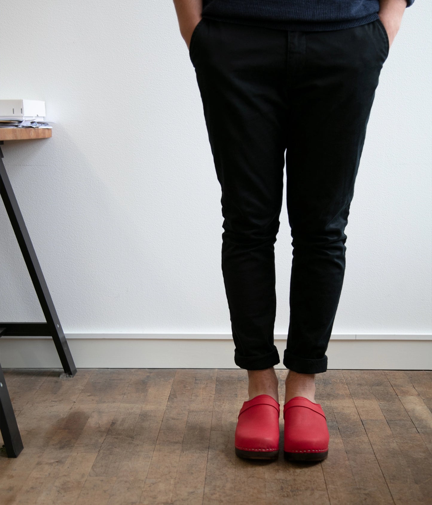 low heeled classic clog mule in red nubuck leather stapled on a dark wooden base