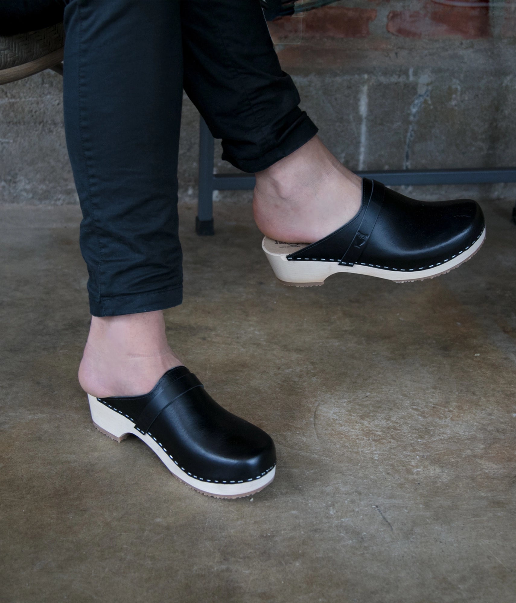 low heeled classic clog mules in black vegetable tanned leather stapled on a light wooden base
