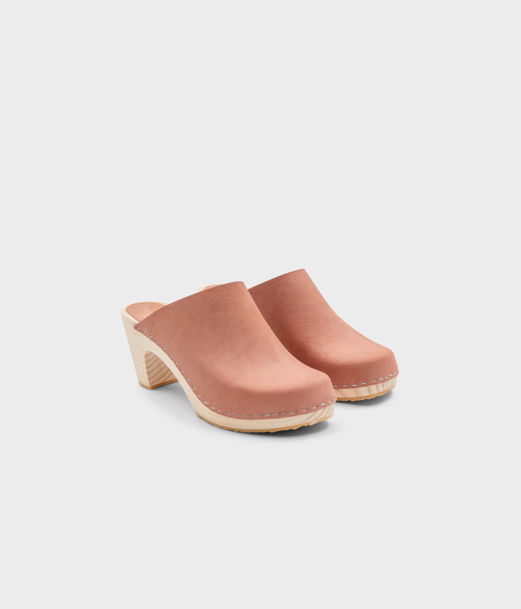 high rise minimalistic clog mule in blush pink nubuck leather stapled on a light wooden base