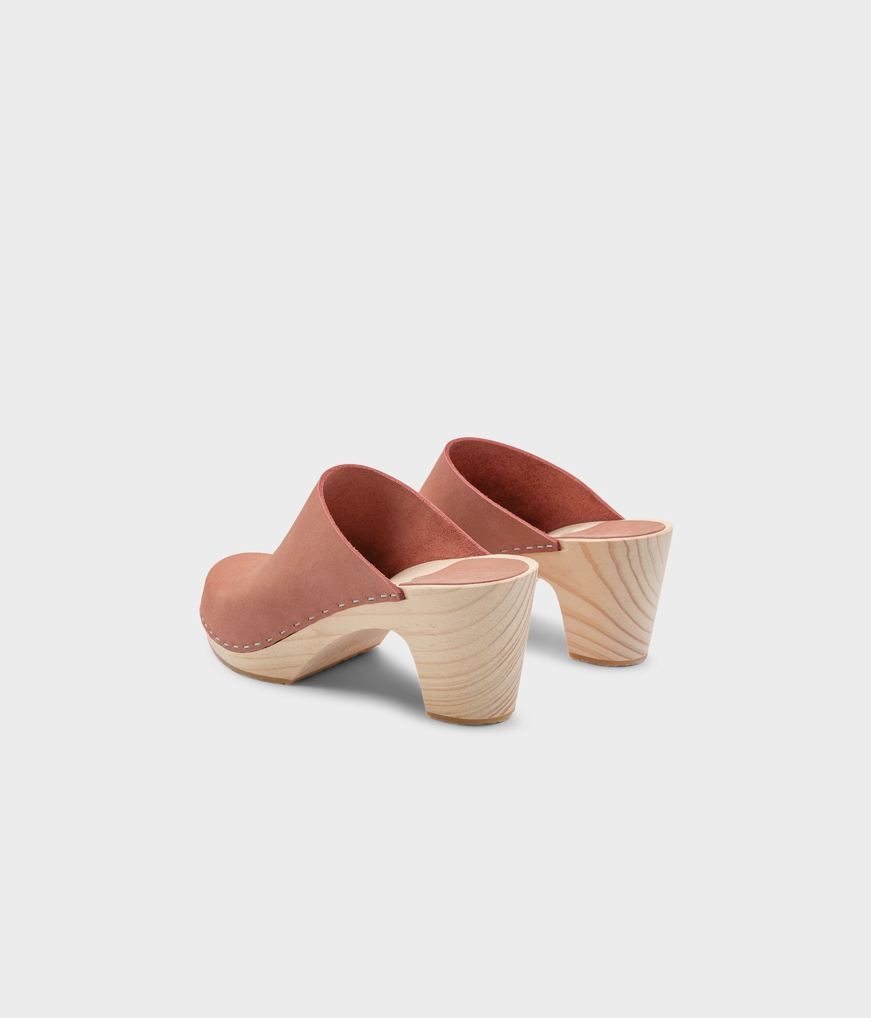 high rise minimalistic clog mule in blush pink nubuck leather stapled on a light wooden base