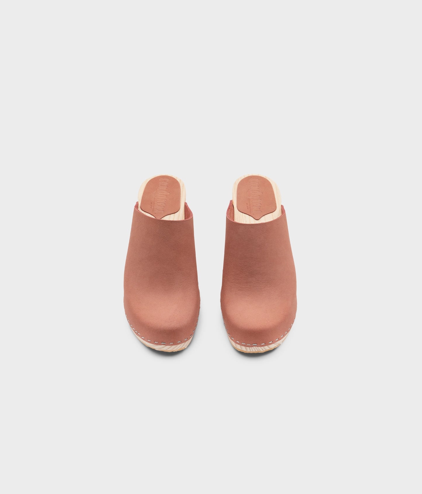high rise minimalistic clog mule in blush pink nubuck leather stapled on a light wooden base