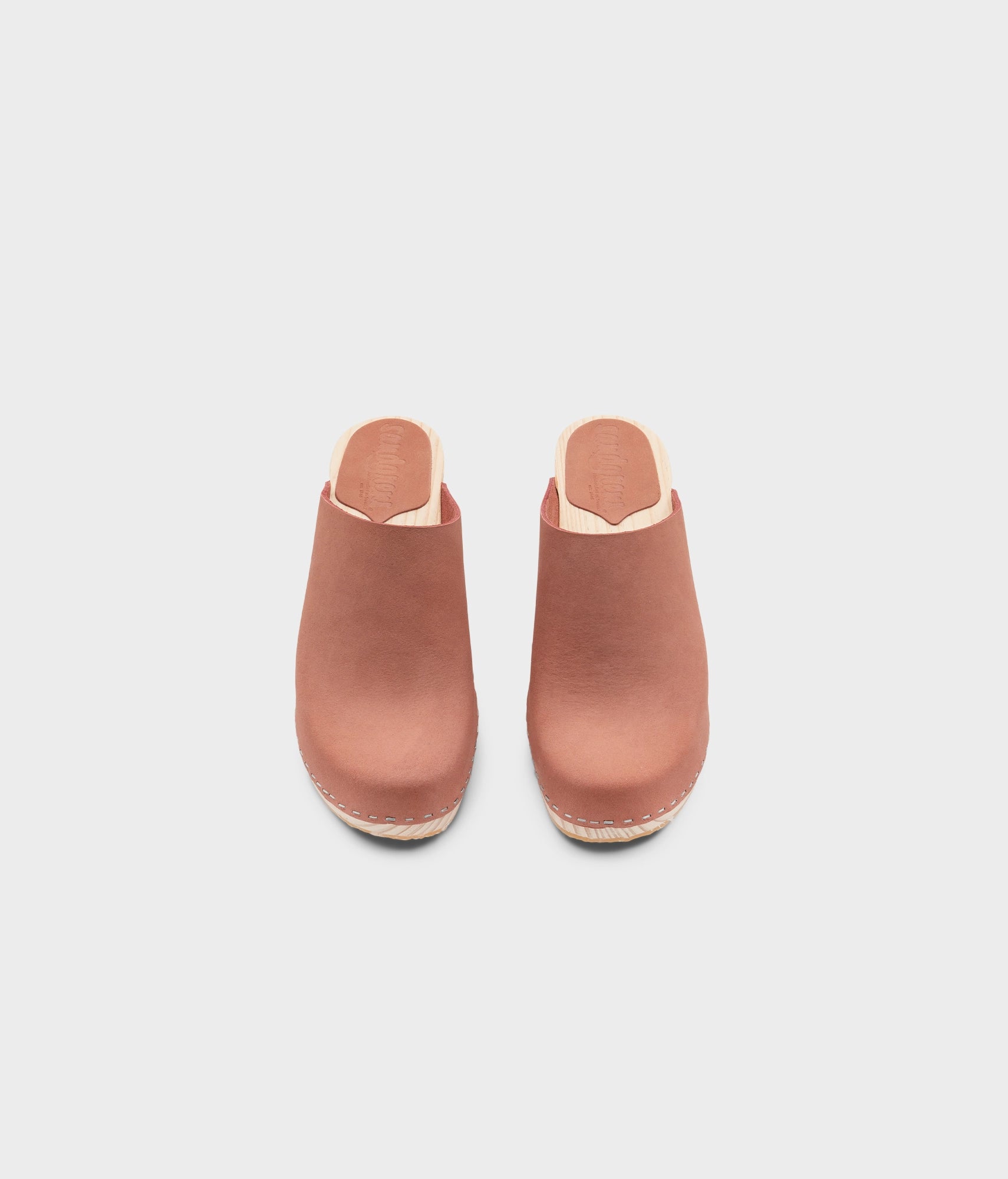 high rise minimalistic clog mule in blush pink nubuck leather stapled on a light wooden base