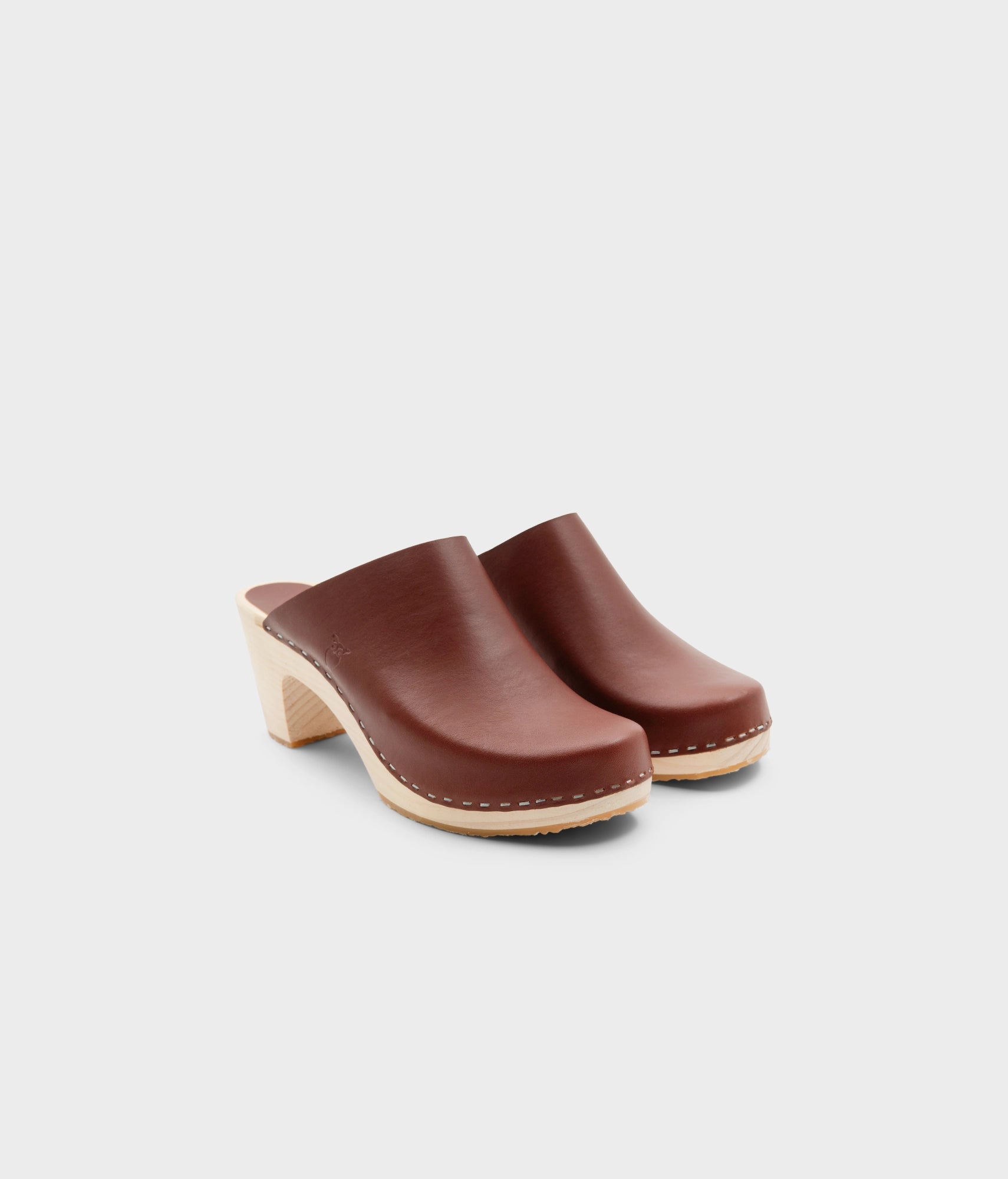 high rise minimalistic clog mule in cognac red vegetable tanned leather stapled on a light wooden base