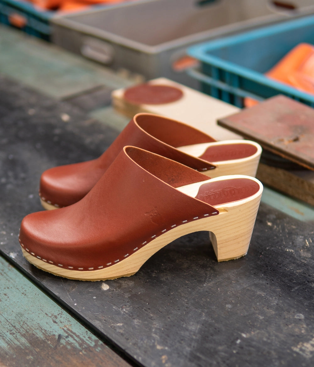 high rise minimalistic clog mule in cognac red vegetable tanned leather stapled on a light wooden base