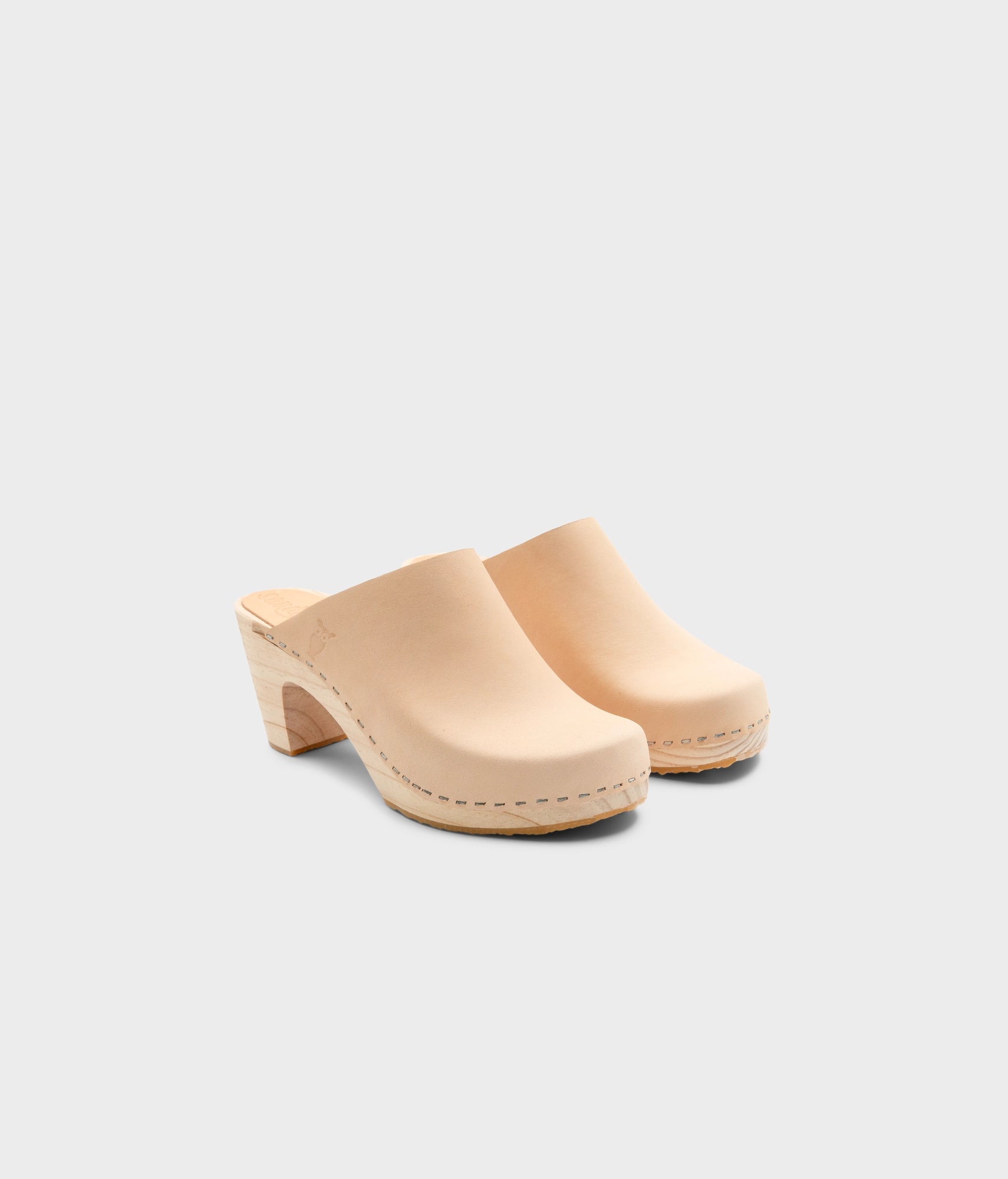 high rise minimalistic clog mule in ecru beige vegetable tanned leather stapled on a light wooden base