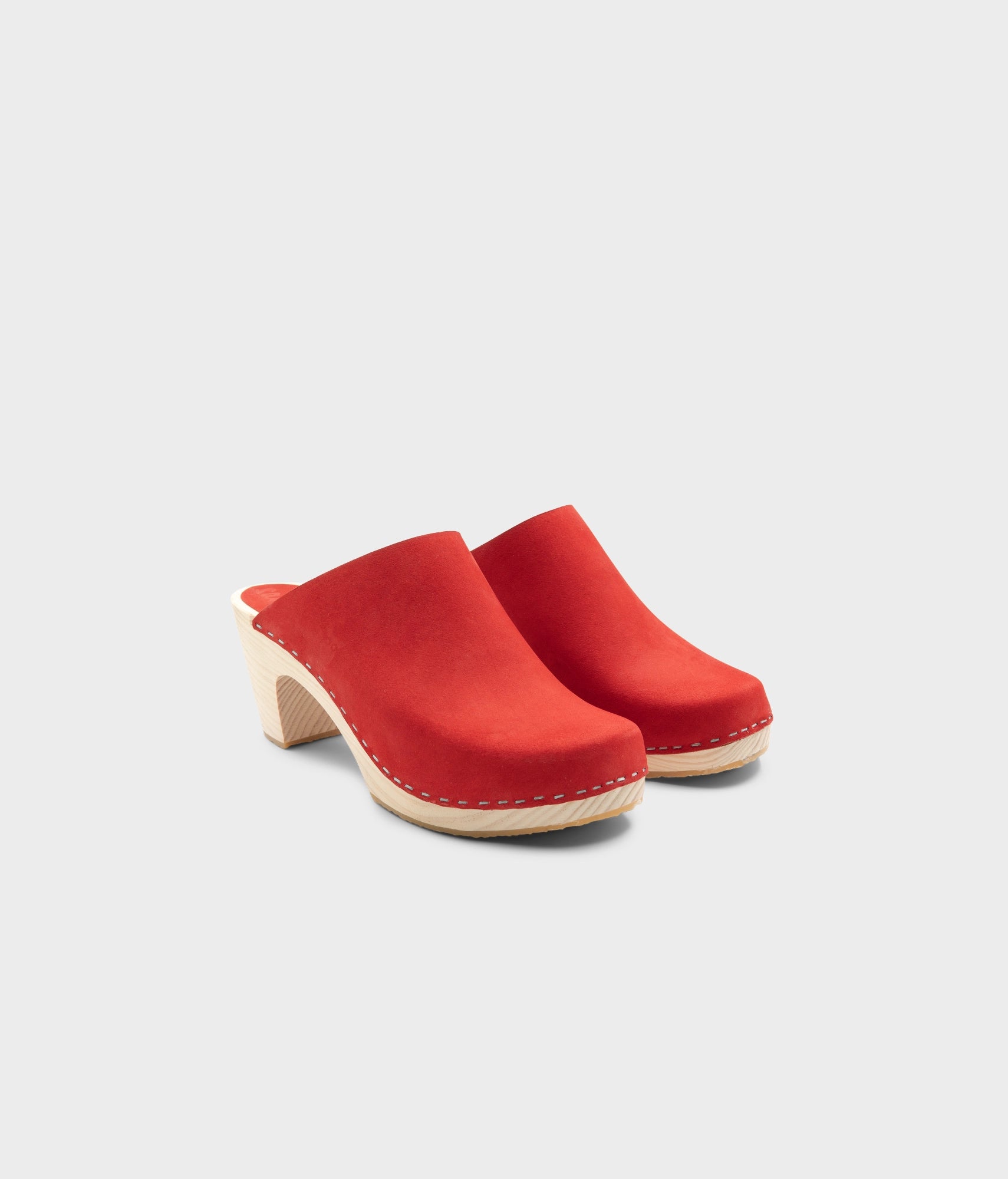 high rise minimalistic clog mule in red nubuck leather stapled on a light wooden base