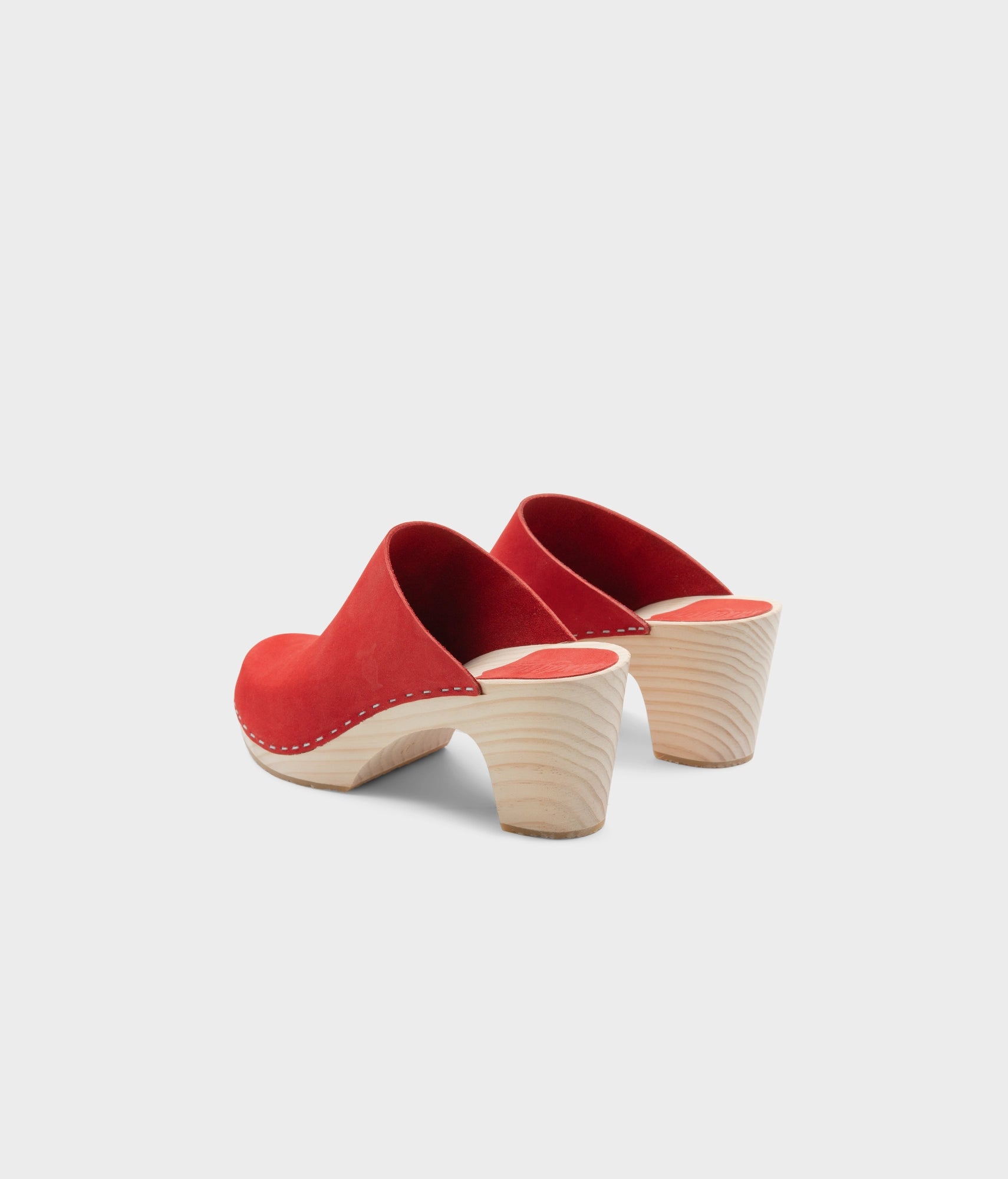 high rise minimalistic clog mule in red nubuck leather stapled on a light wooden base