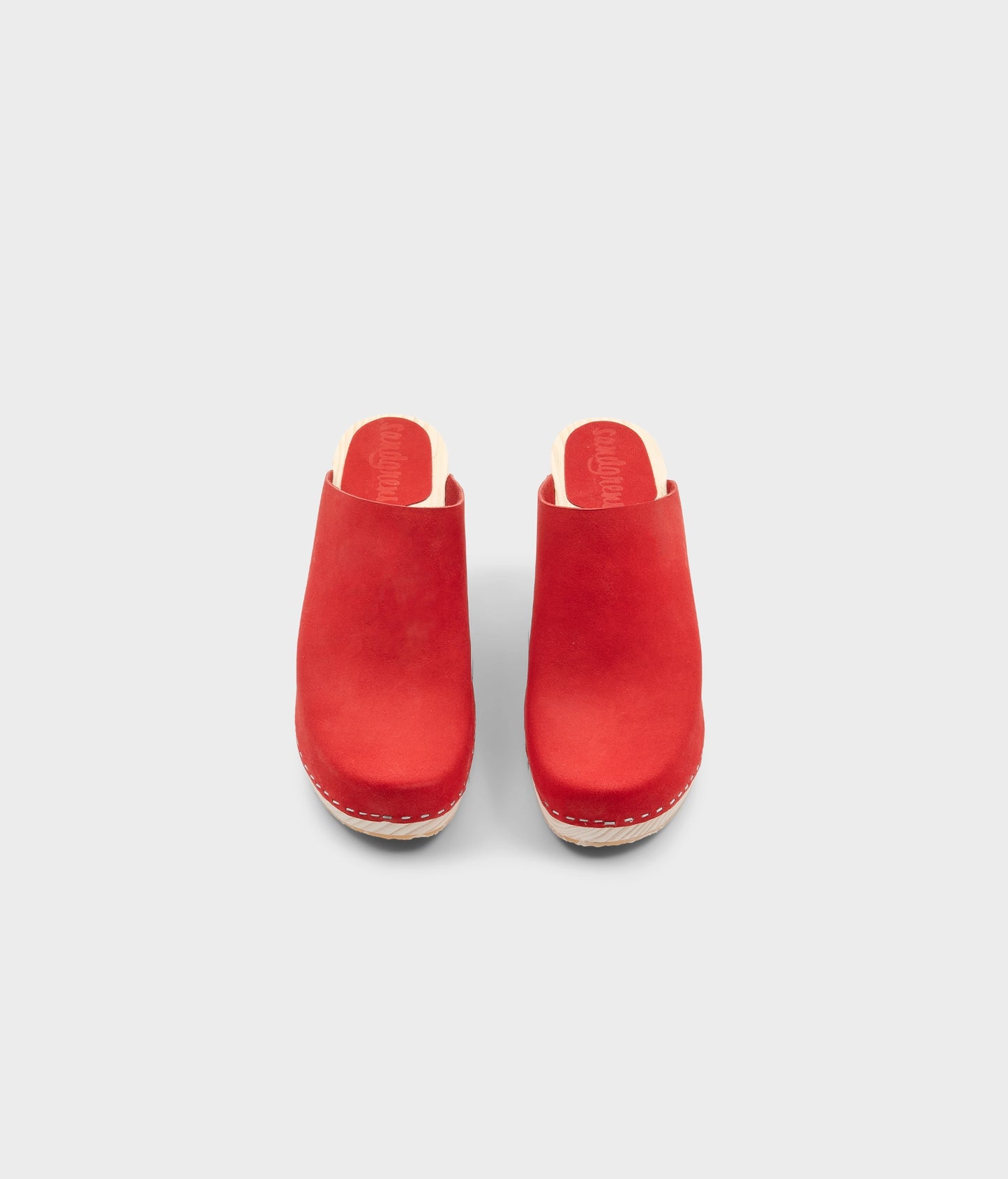 high rise minimalistic clog mule in red nubuck leather stapled on a light wooden base