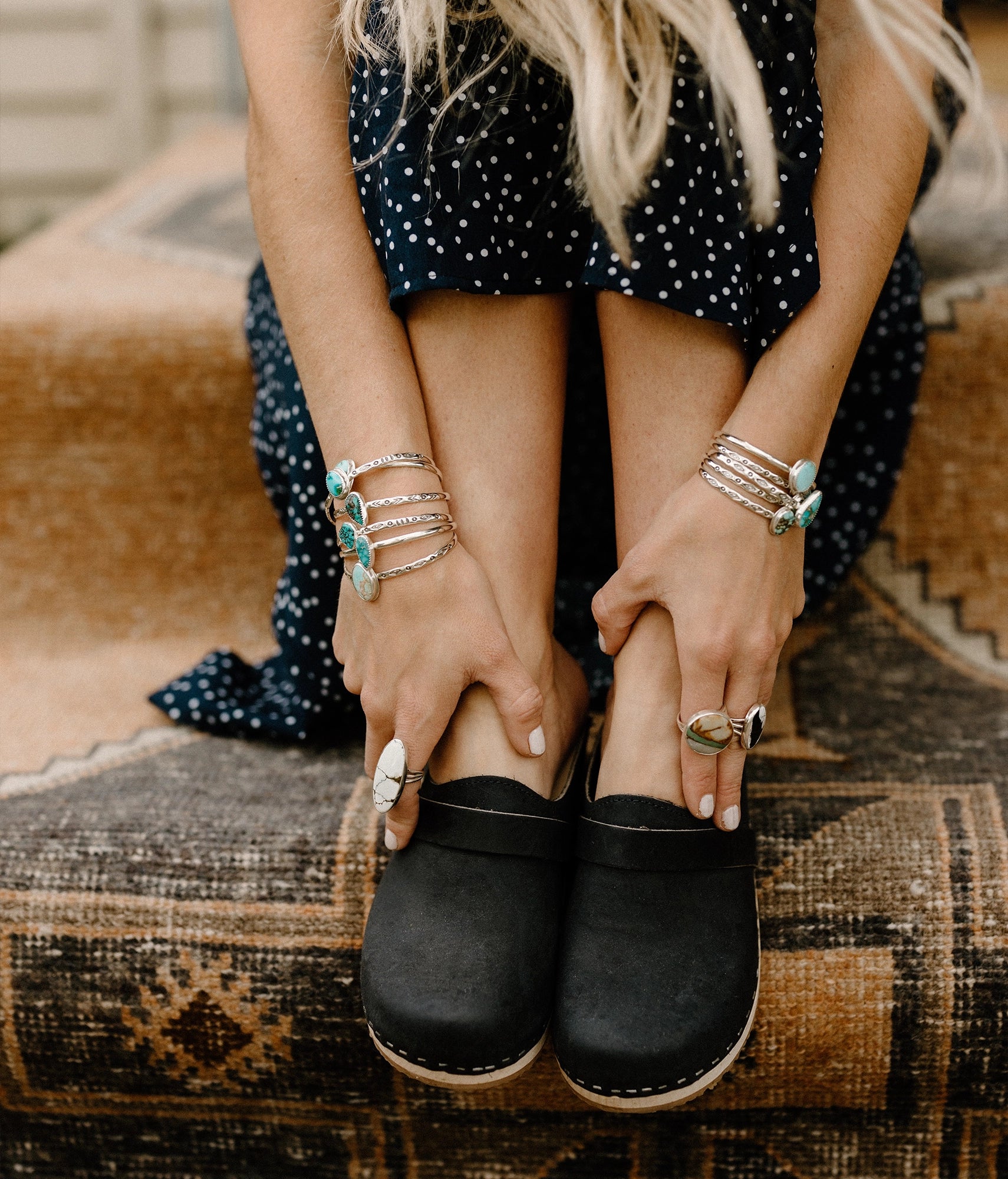 classic low heeled clog mule in black nubuck leather stapled on a light wooden base with a leather strap