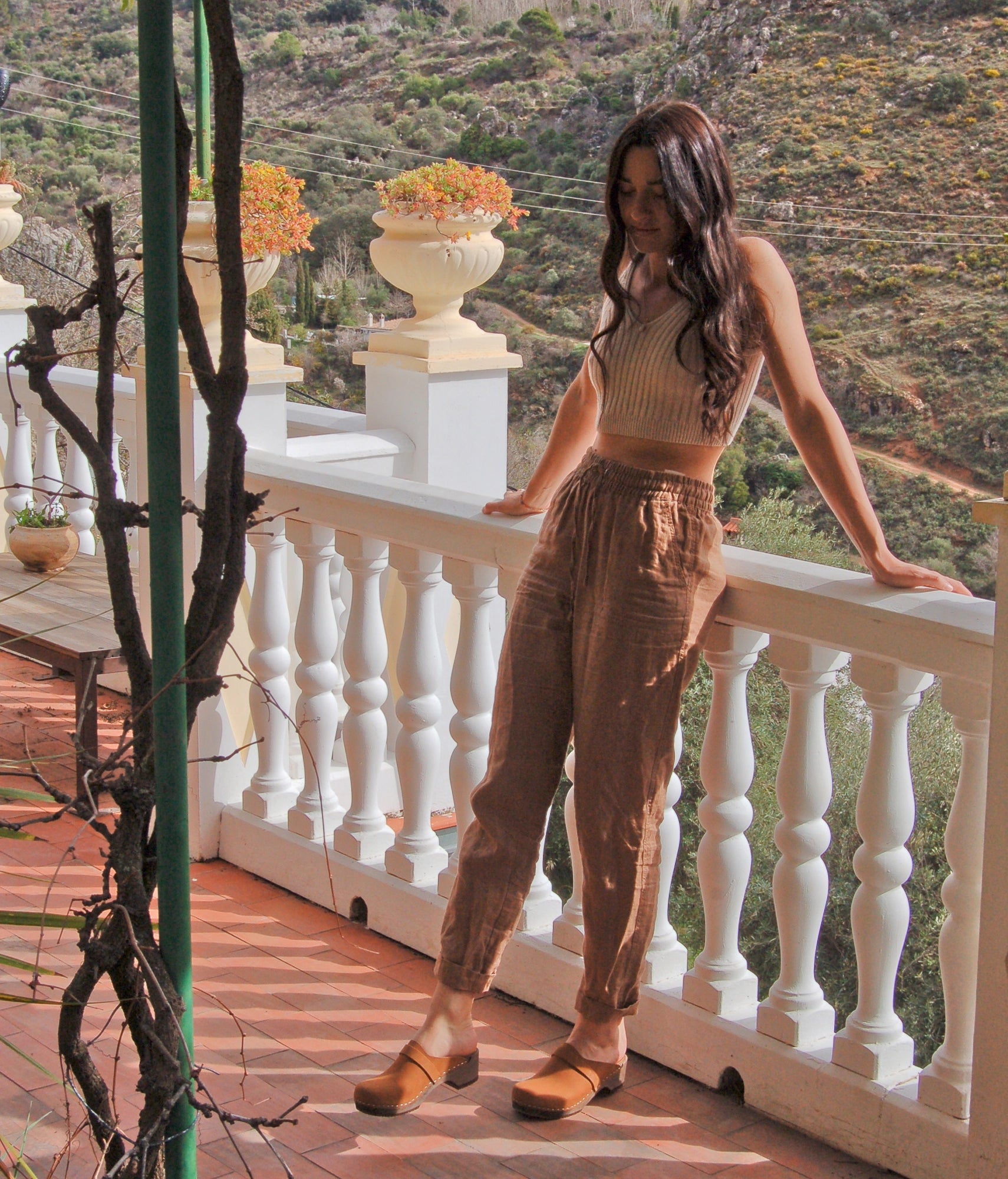 classic low heeled clog mule in light brown nubuck leather stapled on a dark wooden base with a leather strap