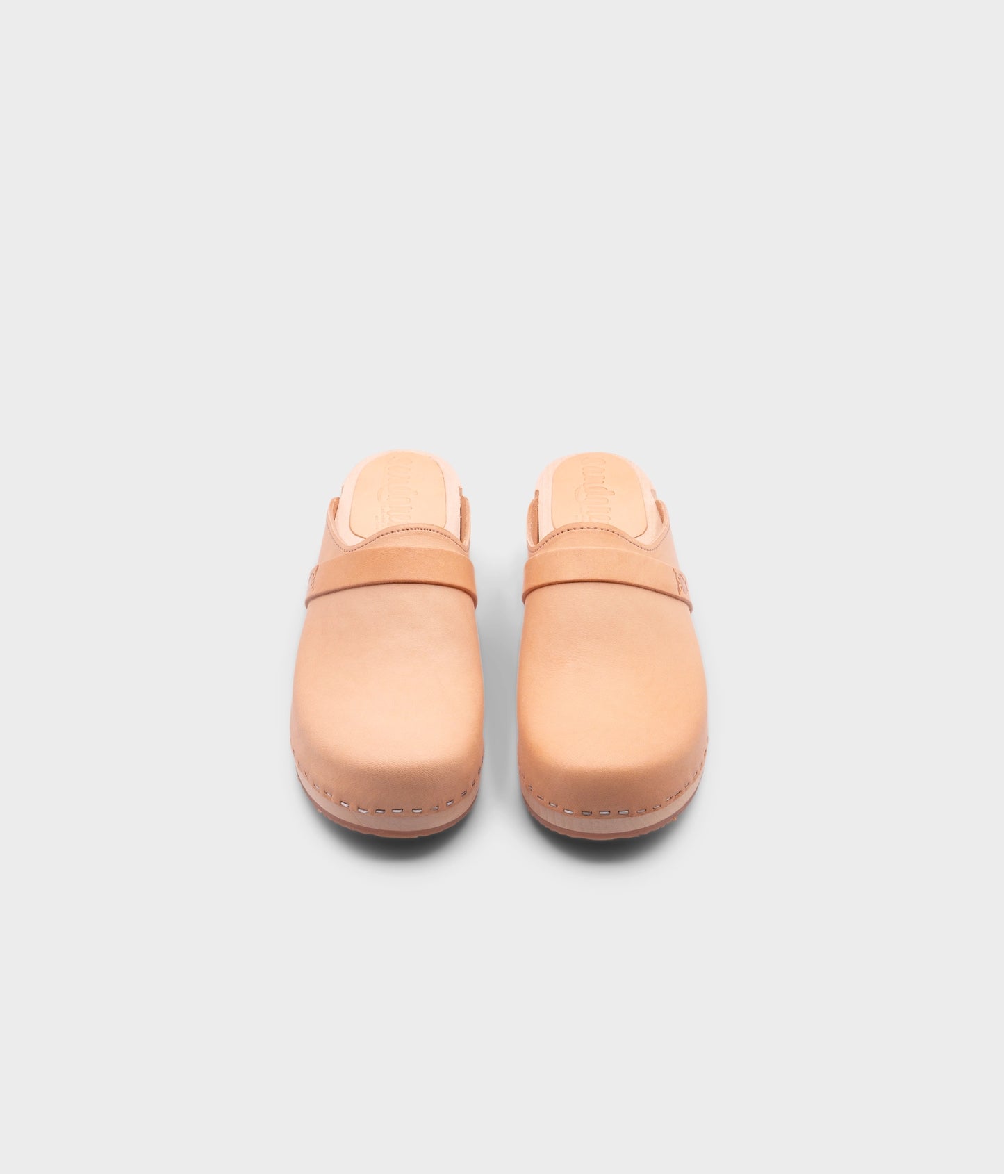 classic low heeled clog mule in beige ecru vegetable tanned leather stapled on a light wooden base with a leather strap