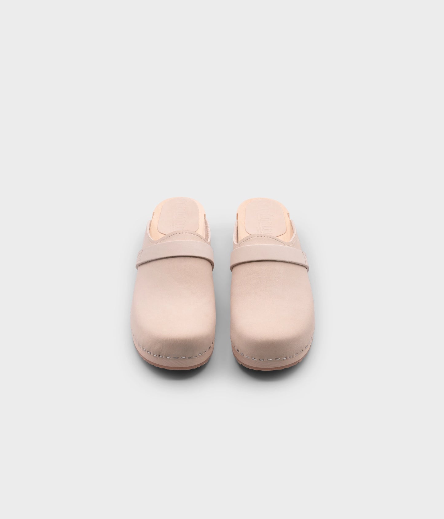 classic low heeled clog mule in sand white nubuck leather stapled on a light wooden base with a leather strap