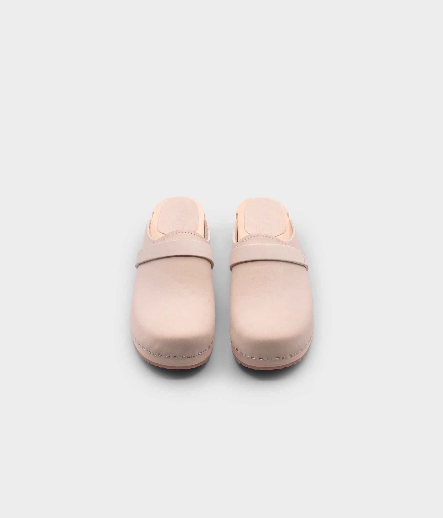 classic low heeled clog mule in sand white nubuck leather stapled on a light wooden base with a leather strap