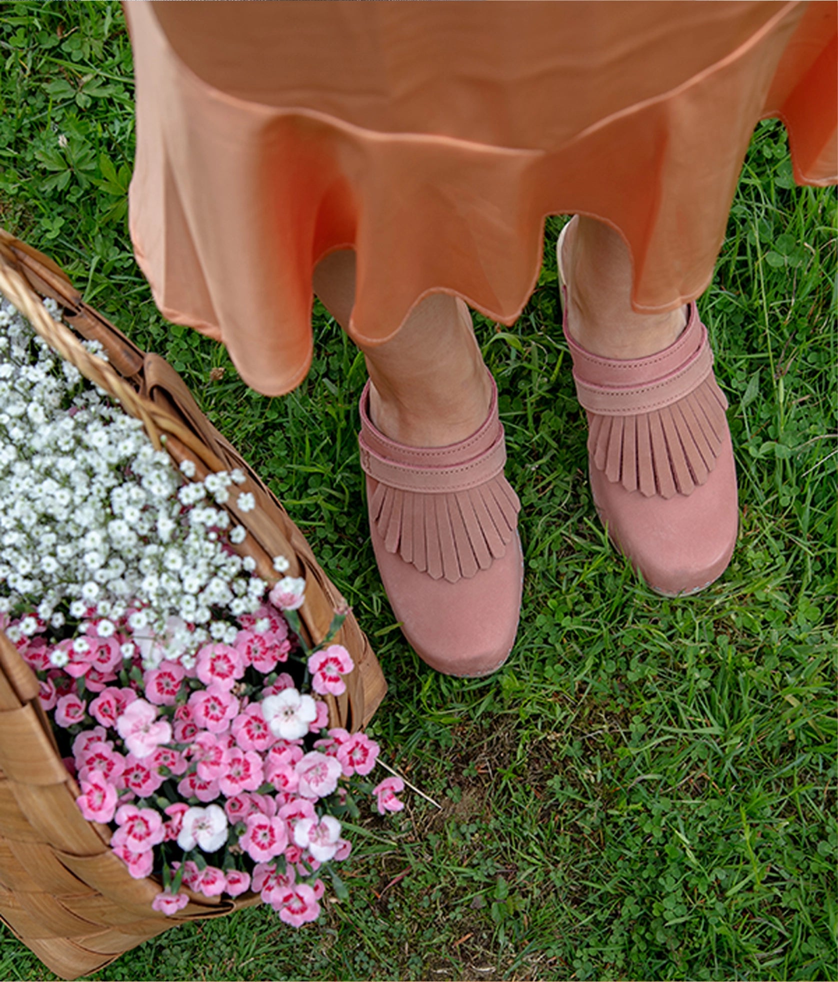 high rise clog mule in blush pink nubuck leather stapled on a light wooden base with a leather strap with fringes