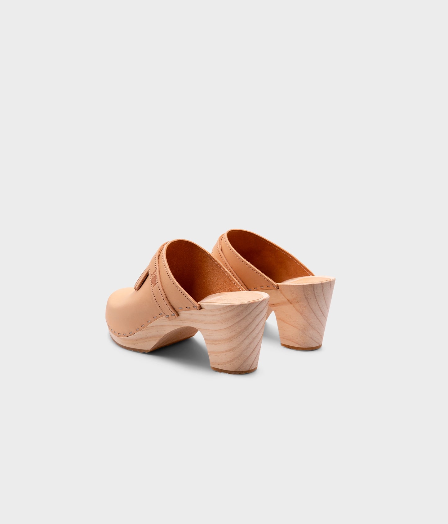 high rise clog mule in ecru beige vegetable tanned leather stapled on a light wooden base with a leather strap with fringes