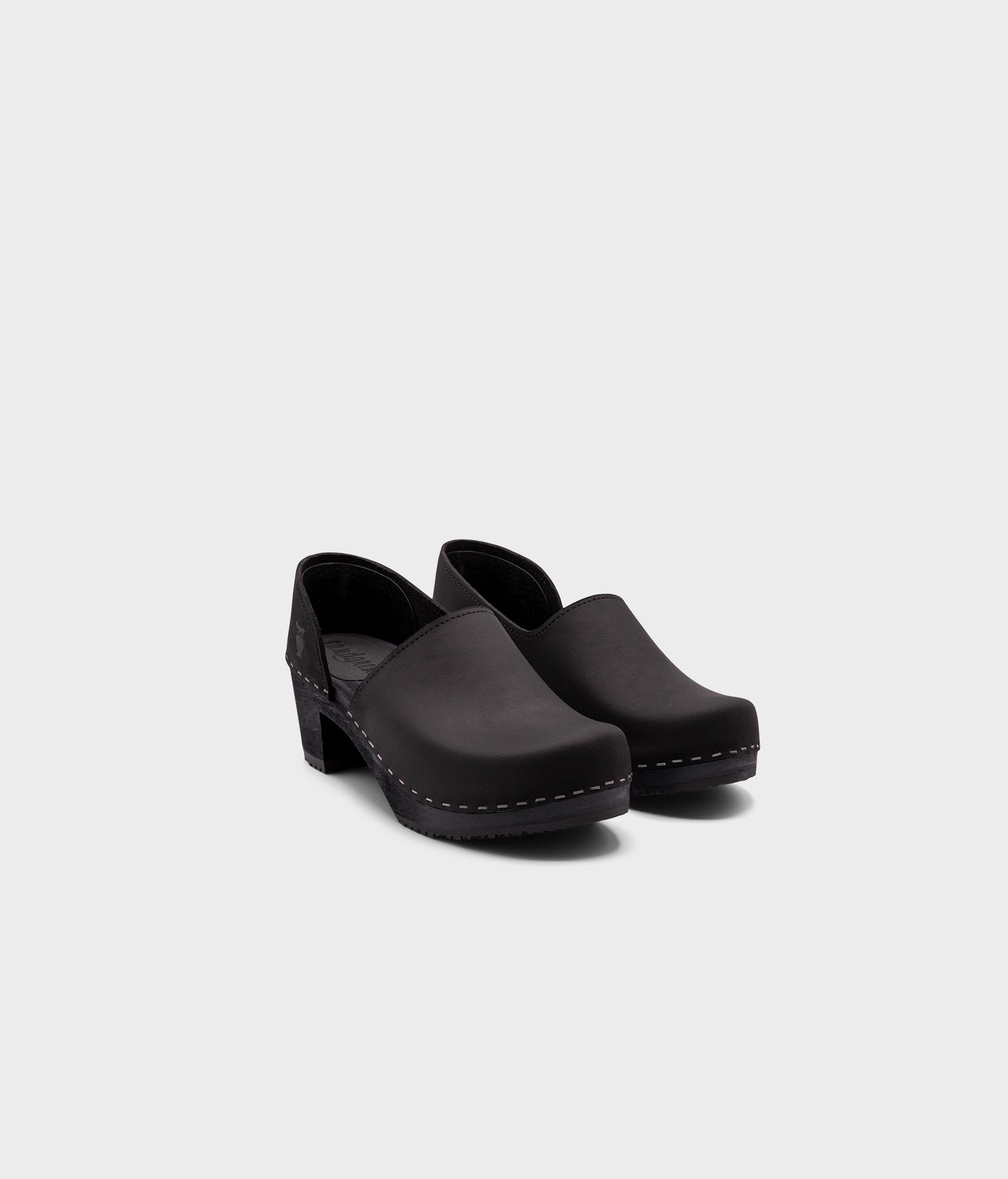 high heeled closed-back clogs in black nubuck leather stapled on a black wooden base