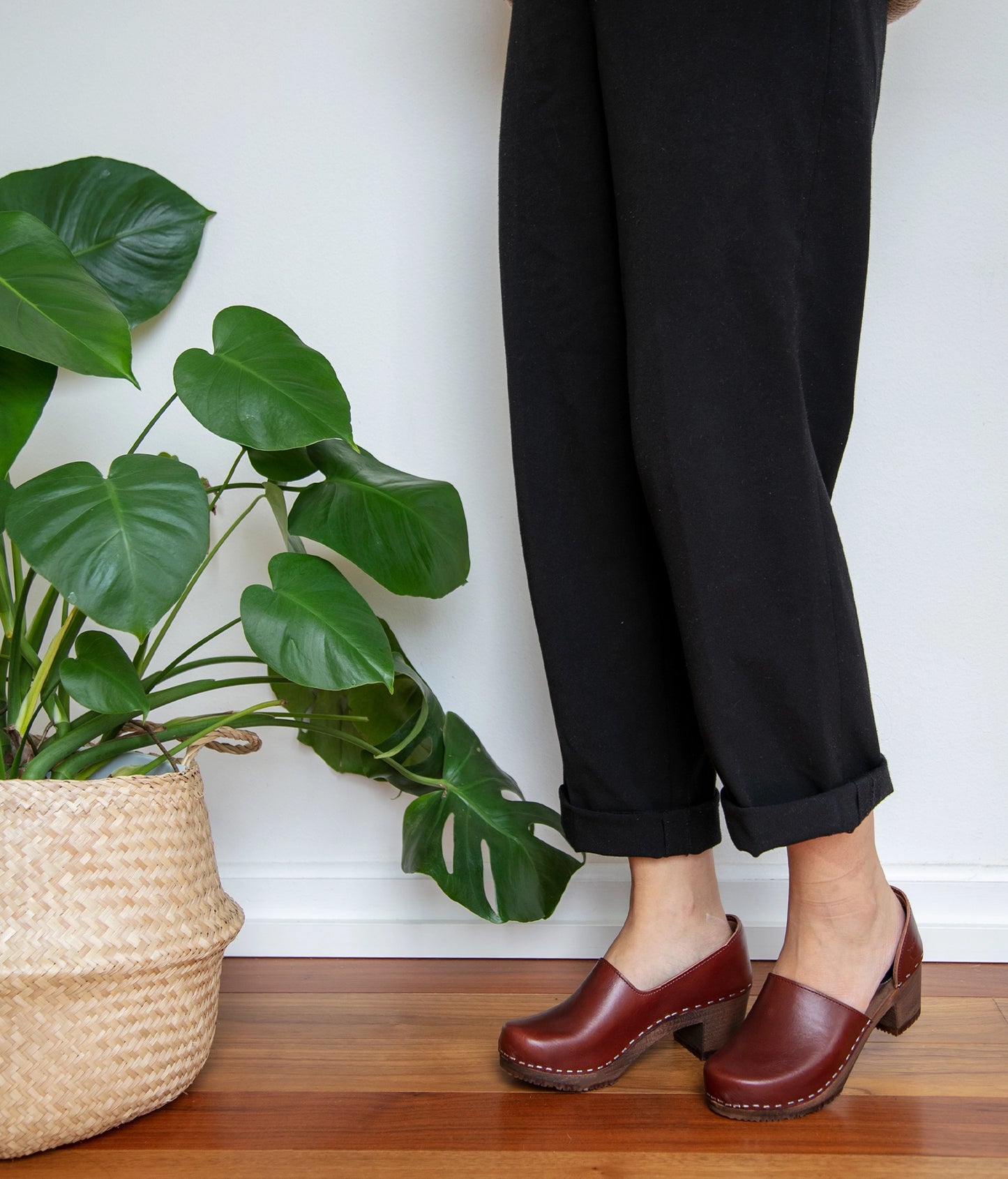 high heeled closed-back clogs in cognac red vegetable tanned leather stapled on a dark wooden base