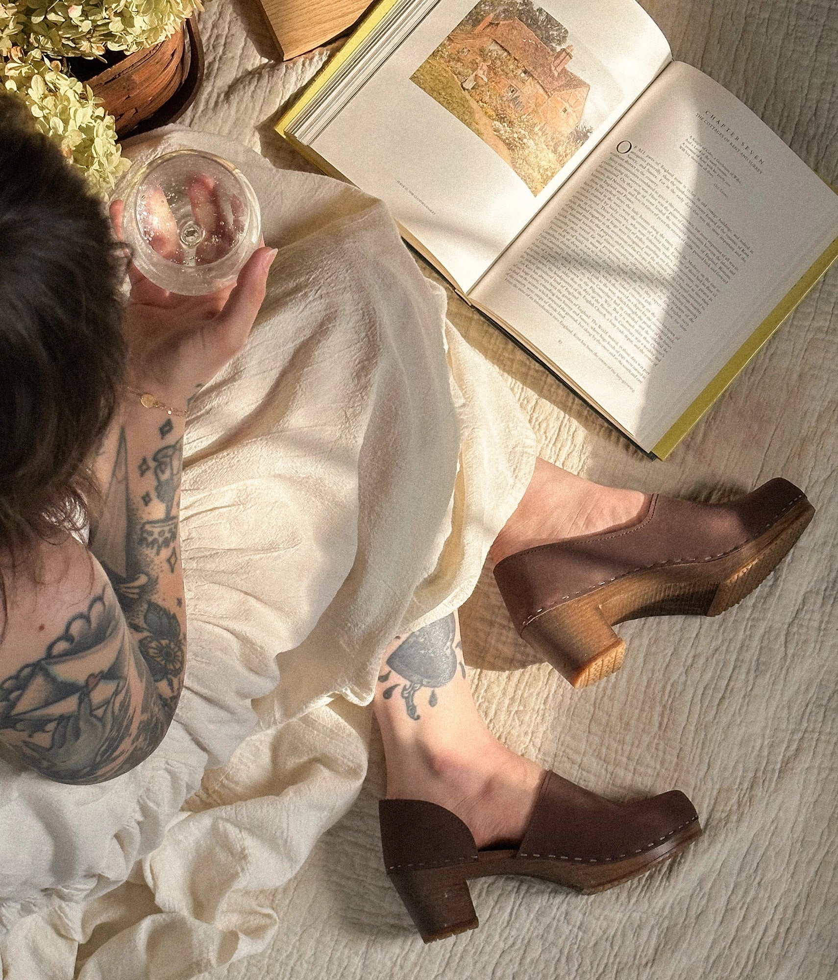 high heeled closed-back clogs in dark brown nubuck leather stapled on a dark wooden base