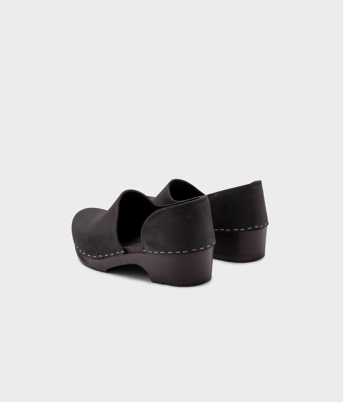 low heeled closed-back clogs in black nubuck leather stapled on a black wooden base