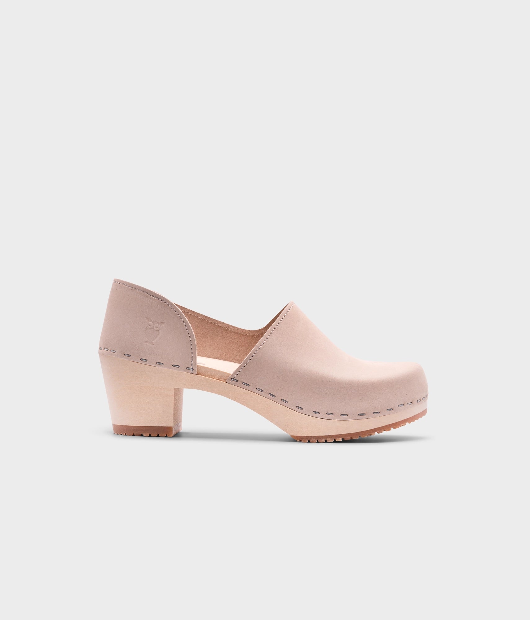 high heeled closed-back clogs in sand white nubuck leather stapled on a light wooden base