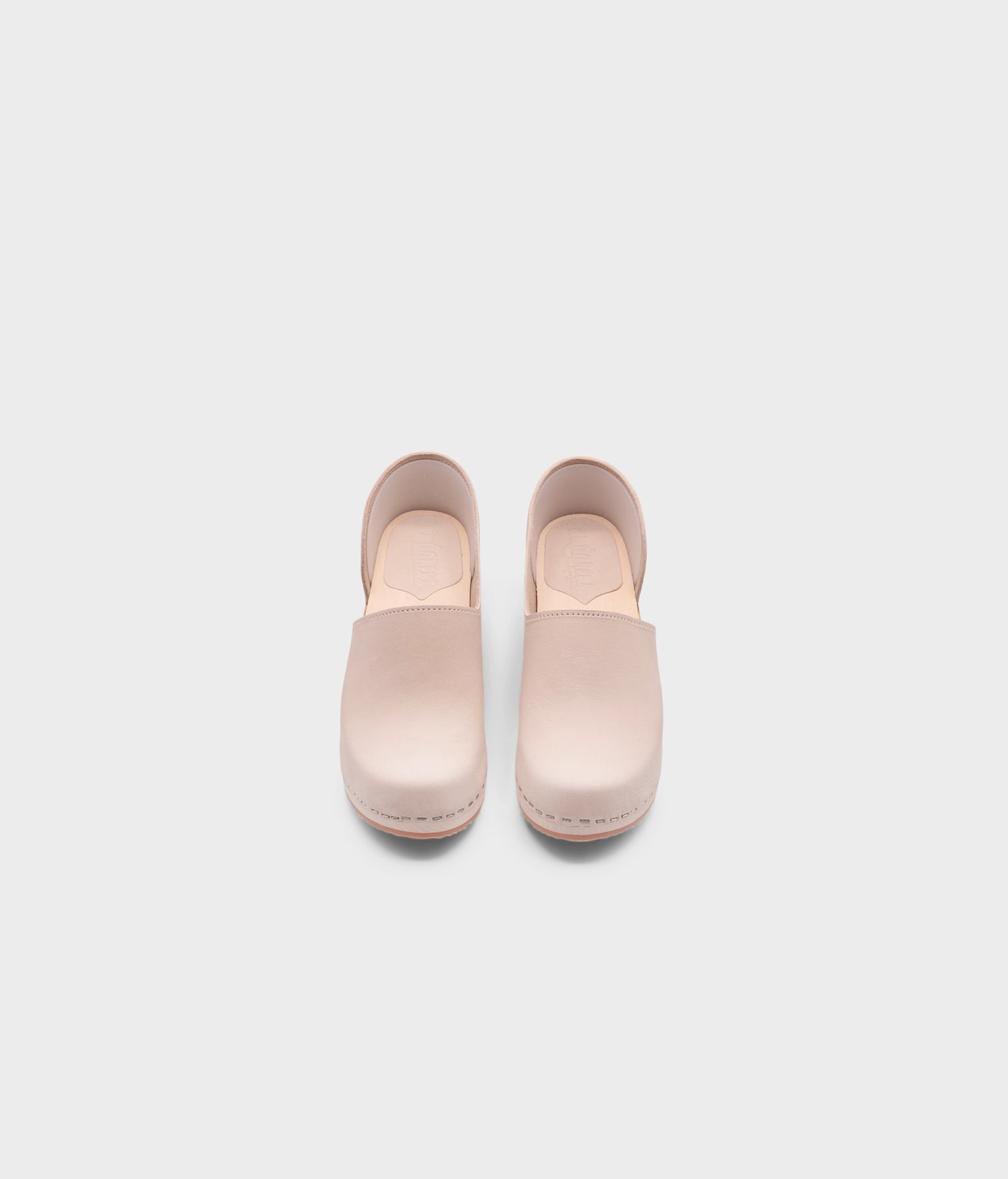 high heeled closed-back clogs in sand white nubuck leather stapled on a light wooden base