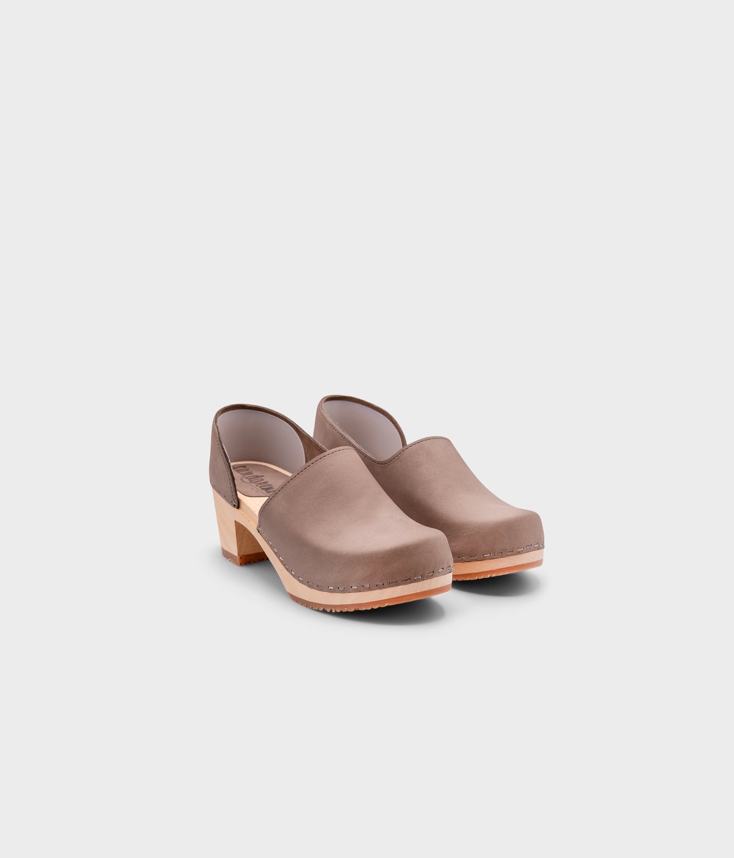 high heeled closed-back clogs in stone grey nubuck leather stapled on a light wooden base