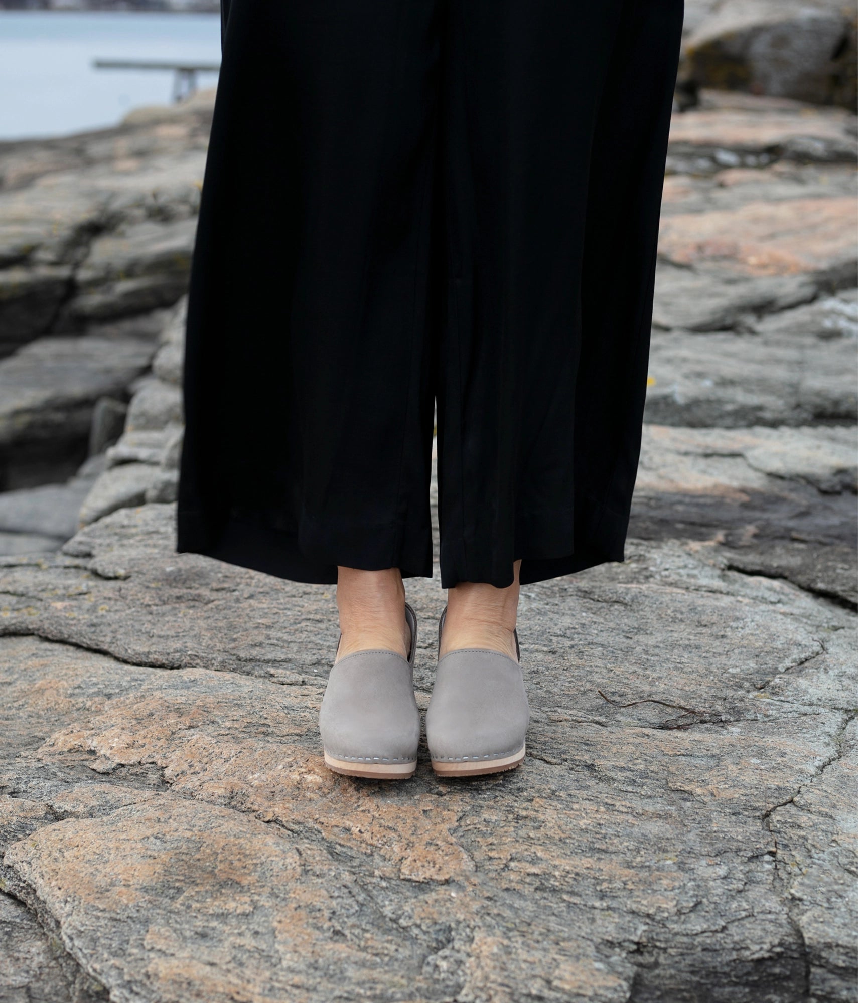 high heeled closed-back clogs in stone grey nubuck leather stapled on a light wooden base