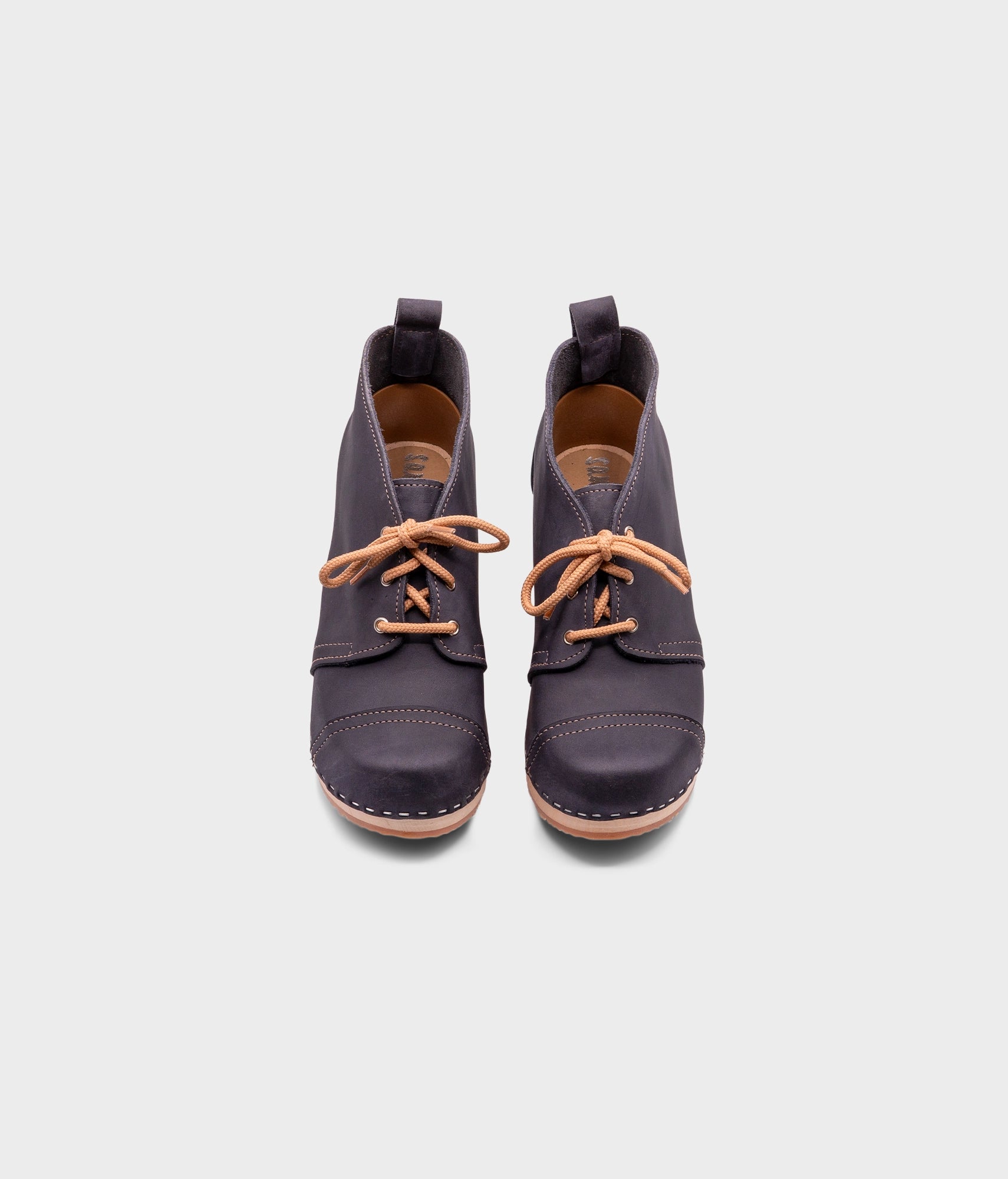 high heeled chukka clog boots in navy blue nubuck leather stapled on a light wooden base with beige laces