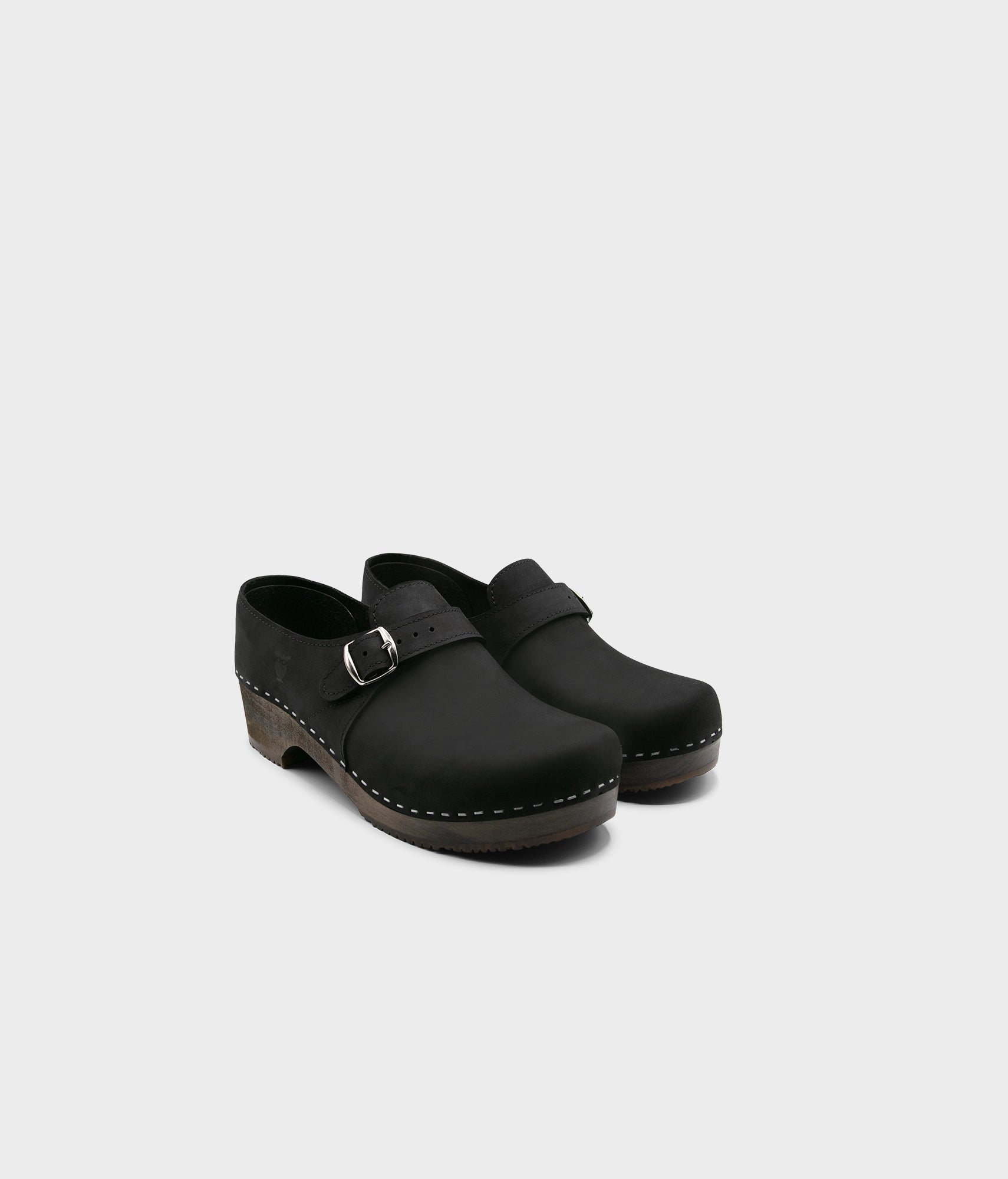 men's closed-back clogs in black nubuck leather stapled on a dark wooden base with a silver buckle
