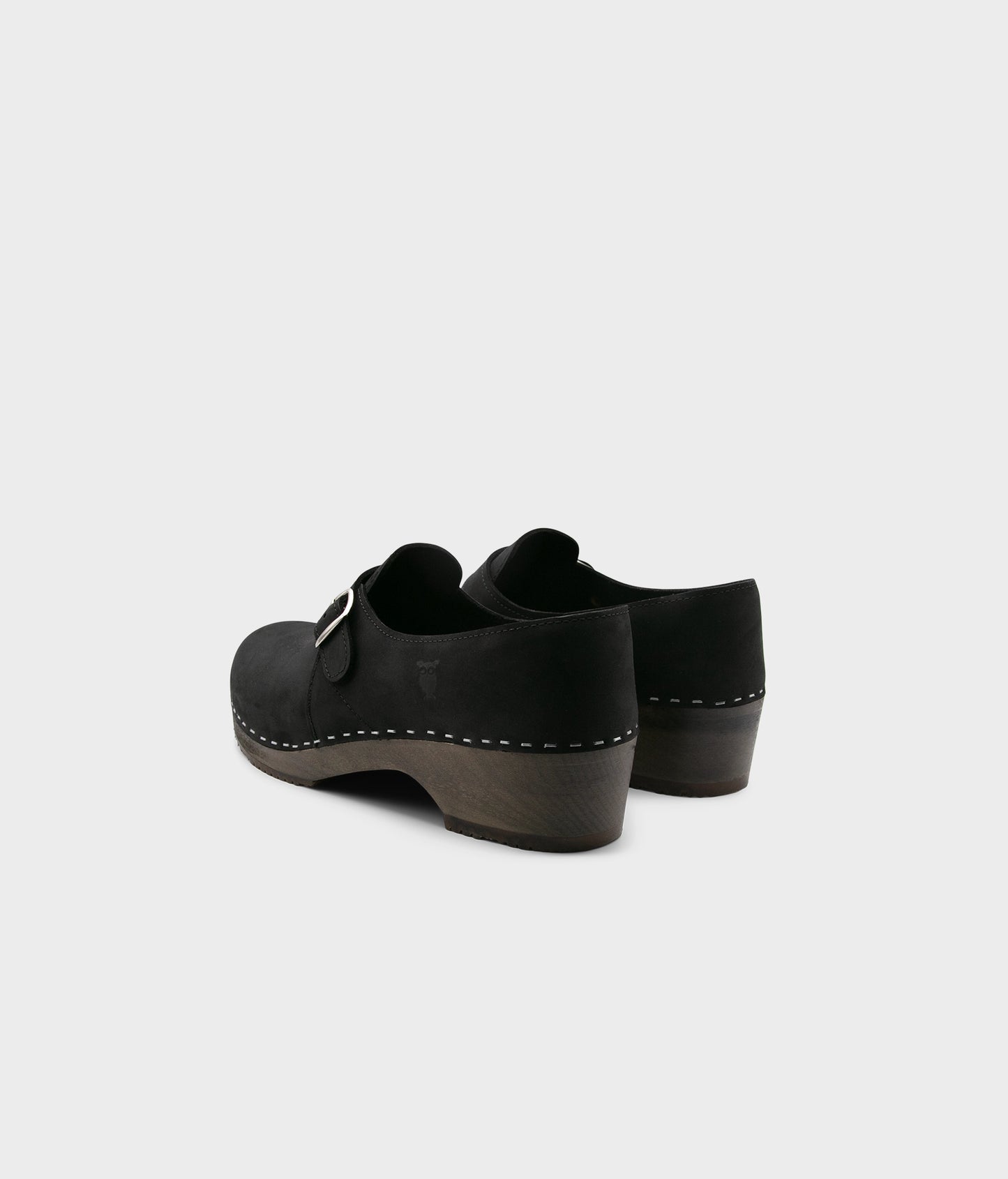 men's closed-back clogs in black nubuck leather stapled on a dark wooden base with a silver buckle
